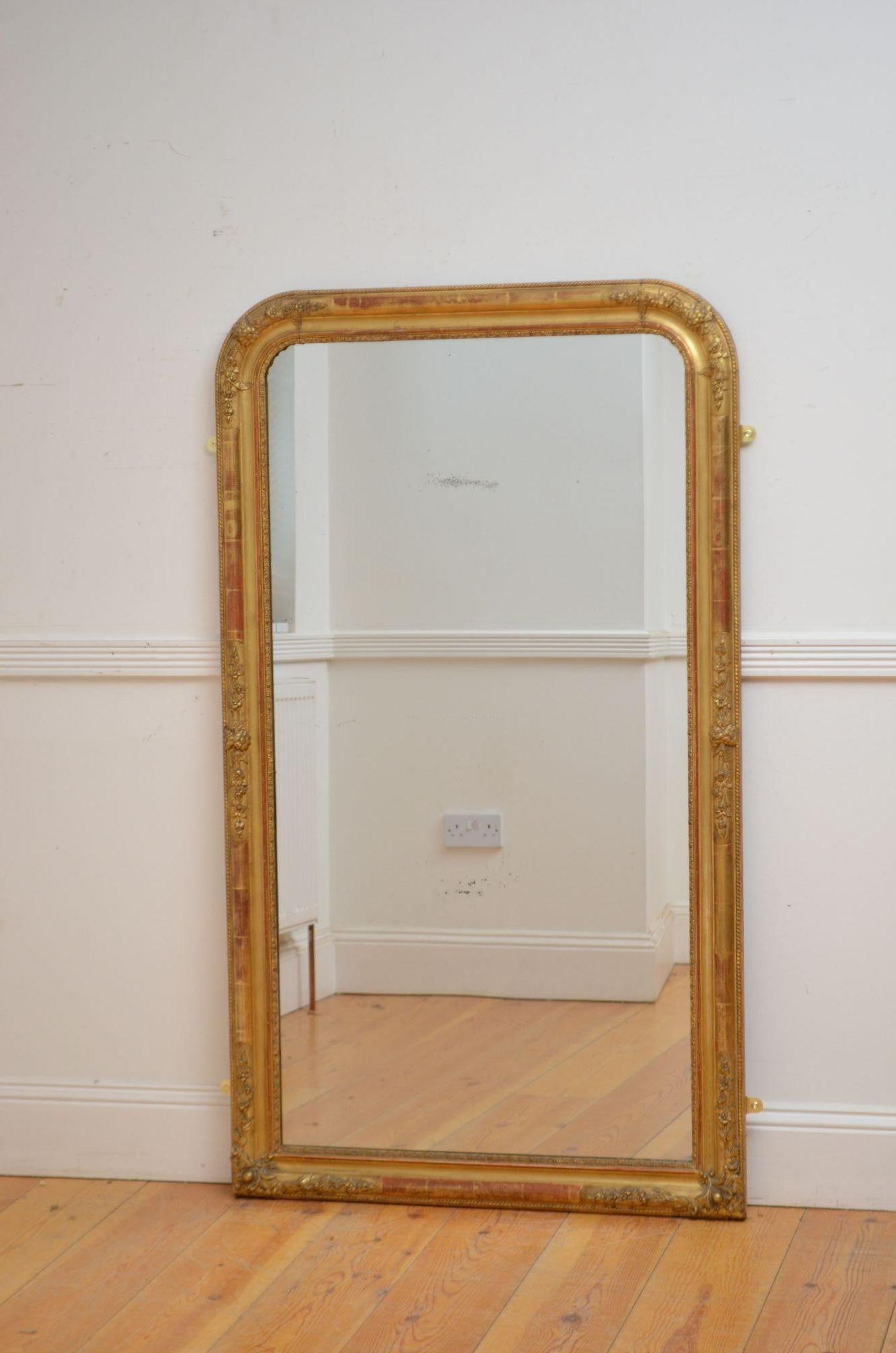  A large French gilded wall mirror of arched form, having original glass with some foxing in moulded and carved gilded frame with carved floral decoration throughout. This antique mirror retains its original glass, original gilt and original
