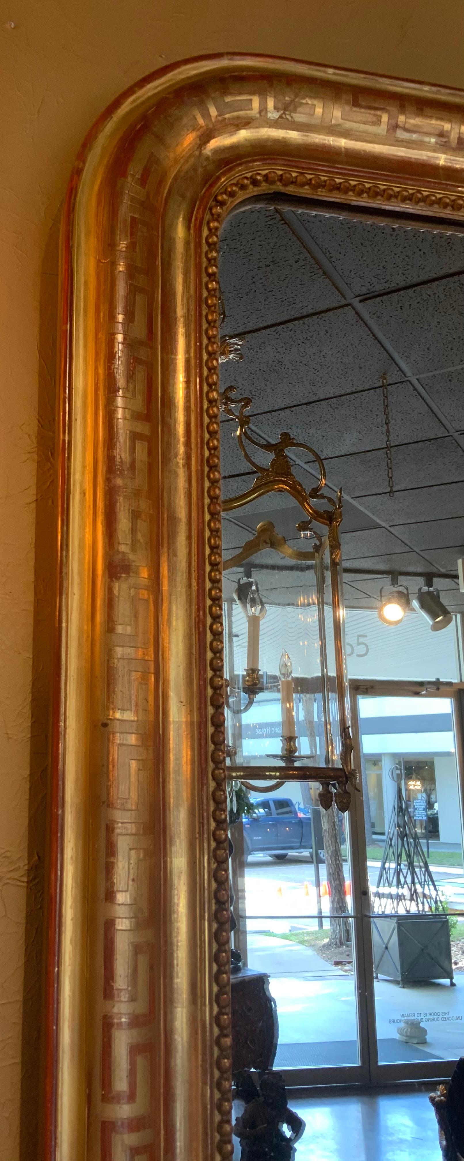 El dorado original es evidente, con un tono rosa claro que brilla
A través de. El marco tiene un diseño de llave griega que recorre todo el perímetro 
Un diseño de abalorios también rodea la placa del espejo. El espejo es original 
A la pieza y es