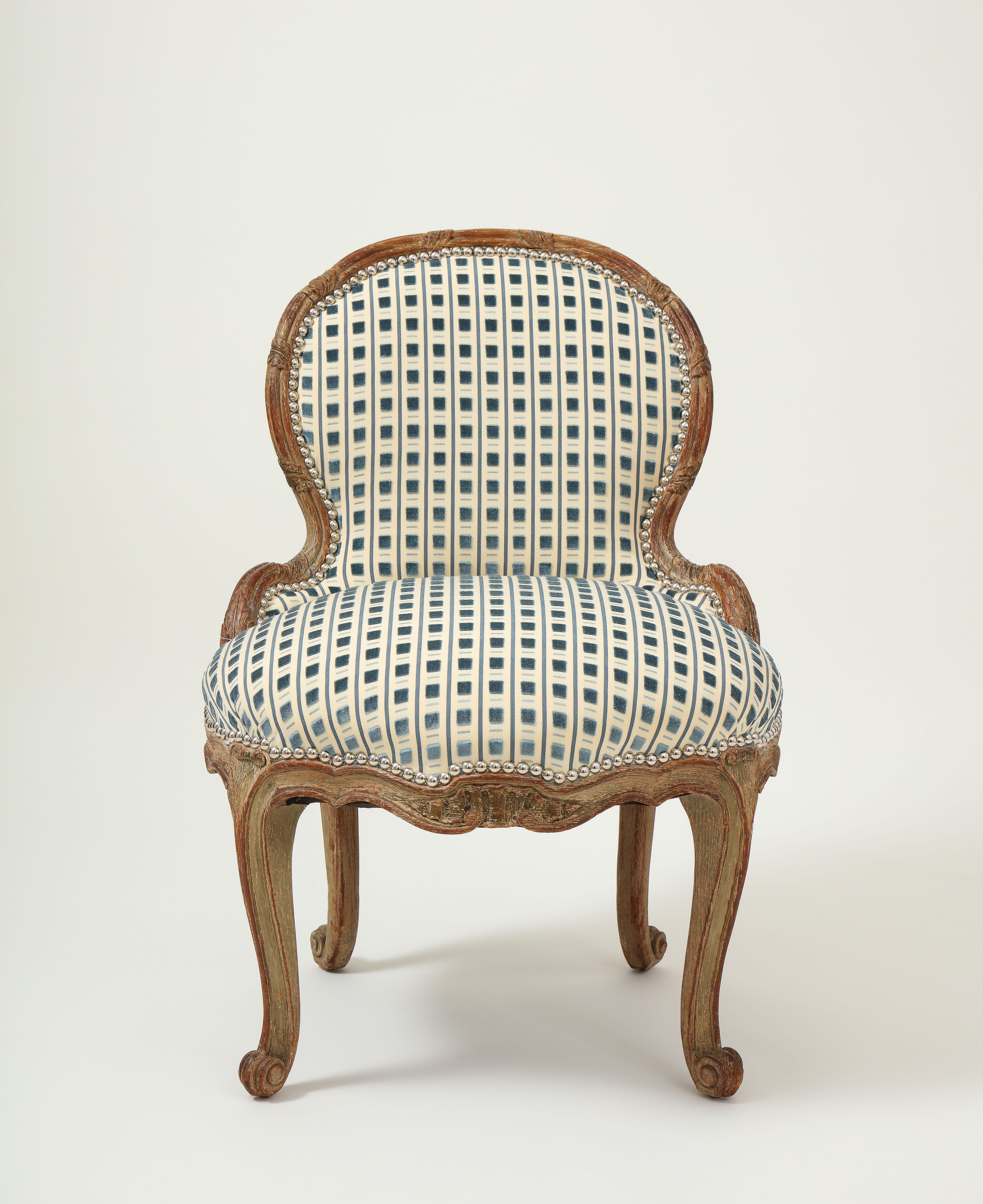 The rounded back reeded with carved foliate clasps; raised on channeled cabriole legs terminating in scroll form feet. Newly upholstered in a Clarence House cut velvet with silvered nail head trim.

Note this is a smaller scale piece, making it