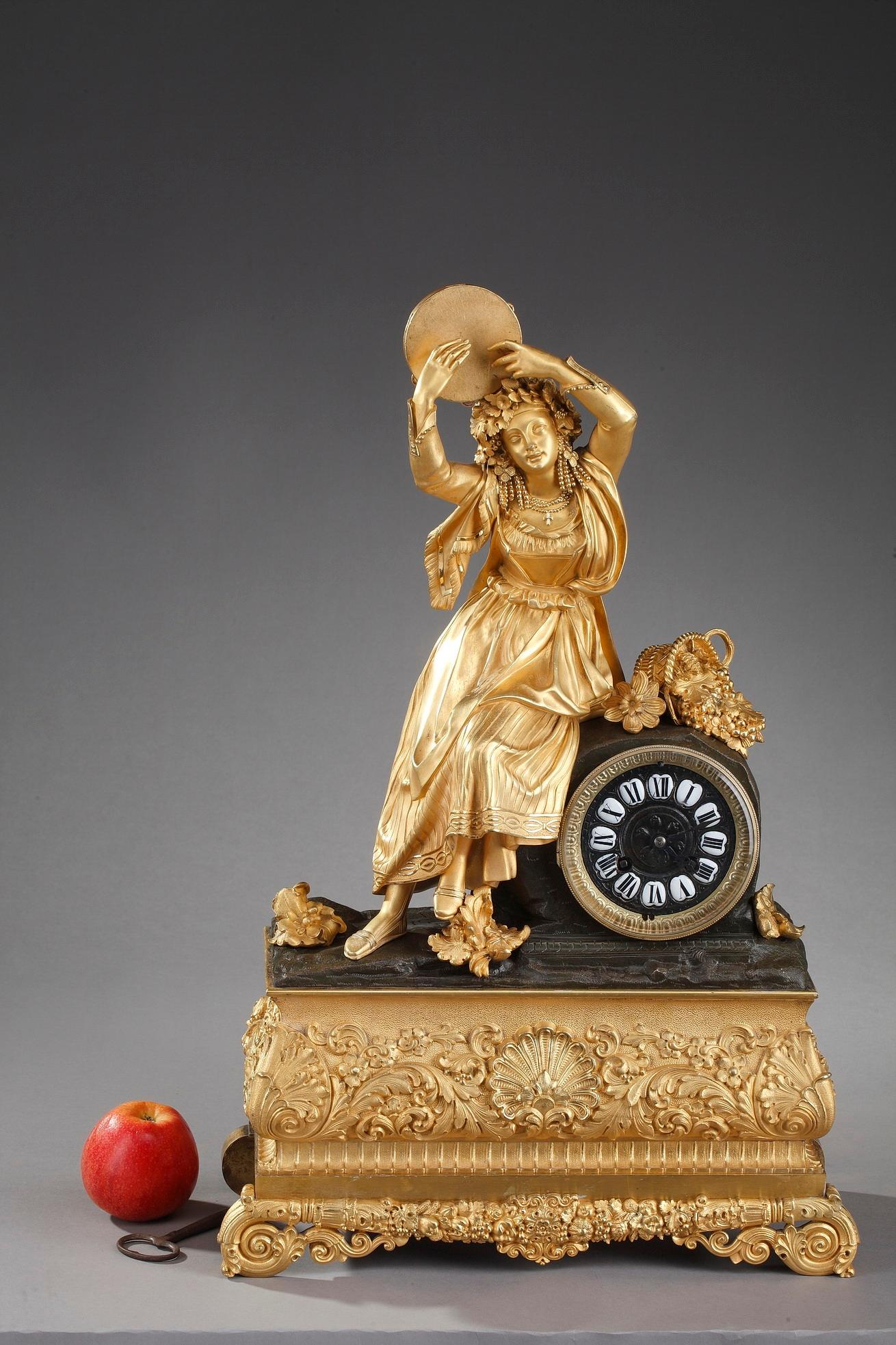 Early 19th century Louis-Philippe figural Ormolu clock featuring an oriental woman playing tambourine. She wears a crown of flowers and a rich pearl jewelry displays. The dancer is Esmeralda, a 16 years old Gypsie girl in Victor Hugo's 1831 novel