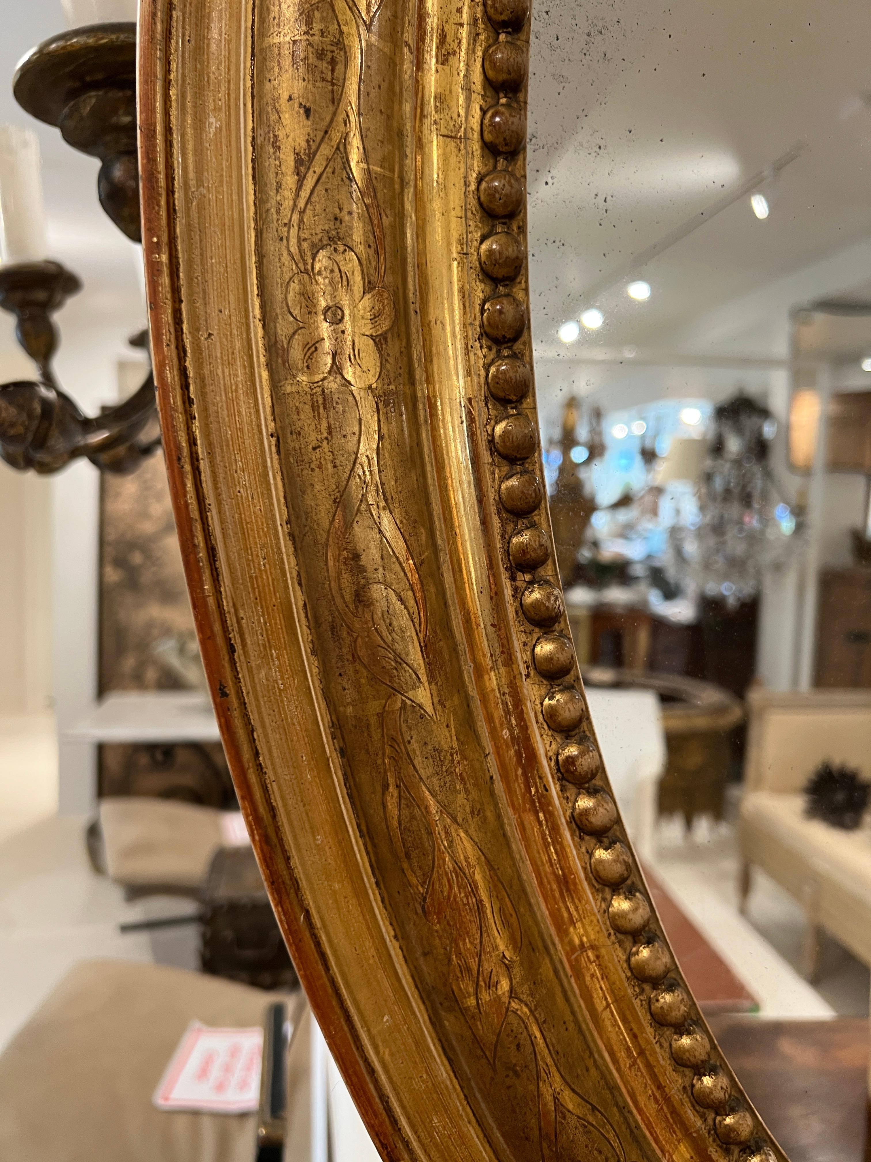 Louis Philippe Oval Hall Mirror. Featuring fine gold gilding and a beaded trim. 
