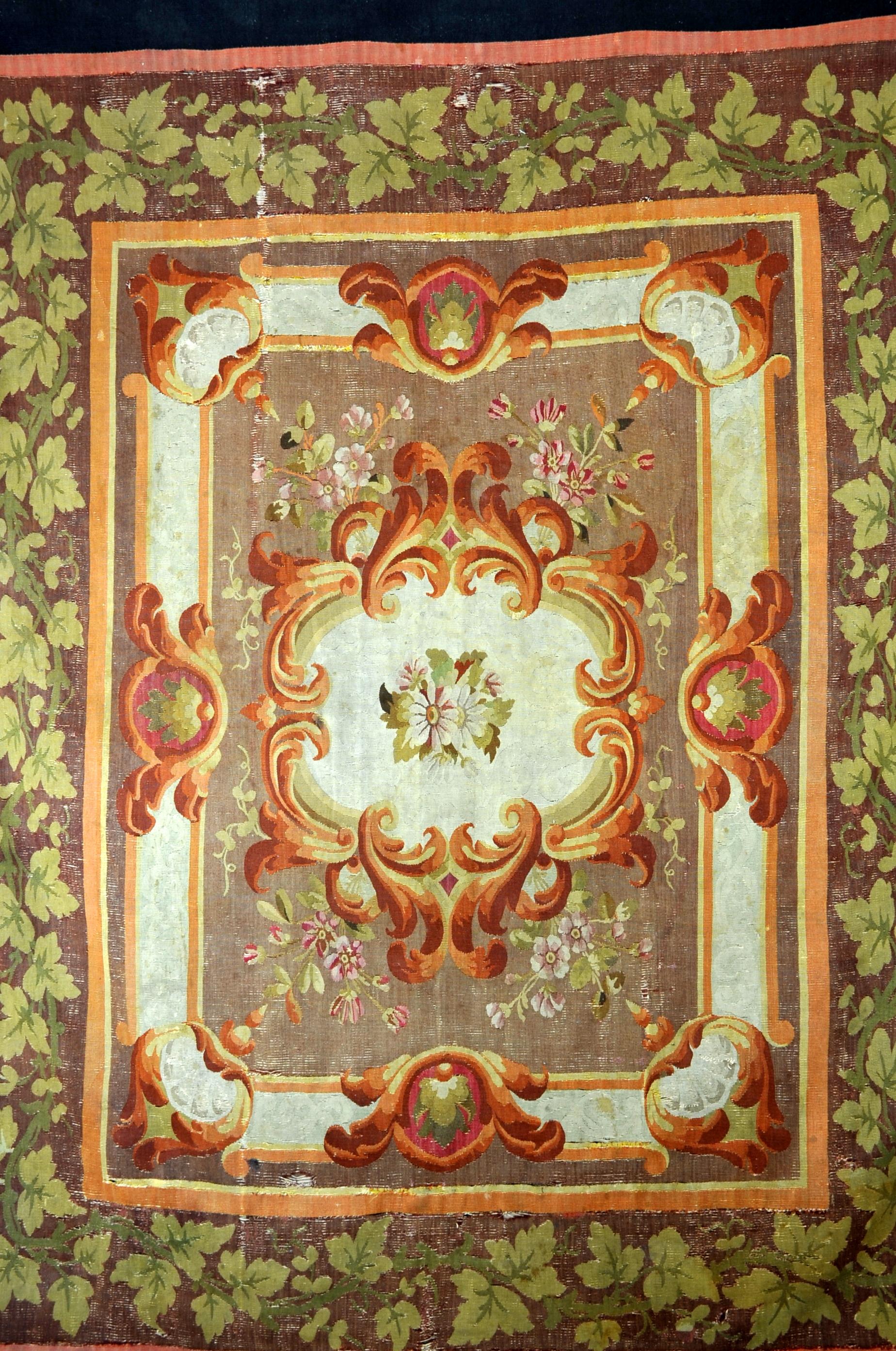 Aubusson rug from the Louis Philippe period with rich foliage decoration, floral and vegetal friezes in orange-brown and green tones.

Dark blue outer border.

Work from the Aubusson factory around 1830.

Good general condition, the colors are
