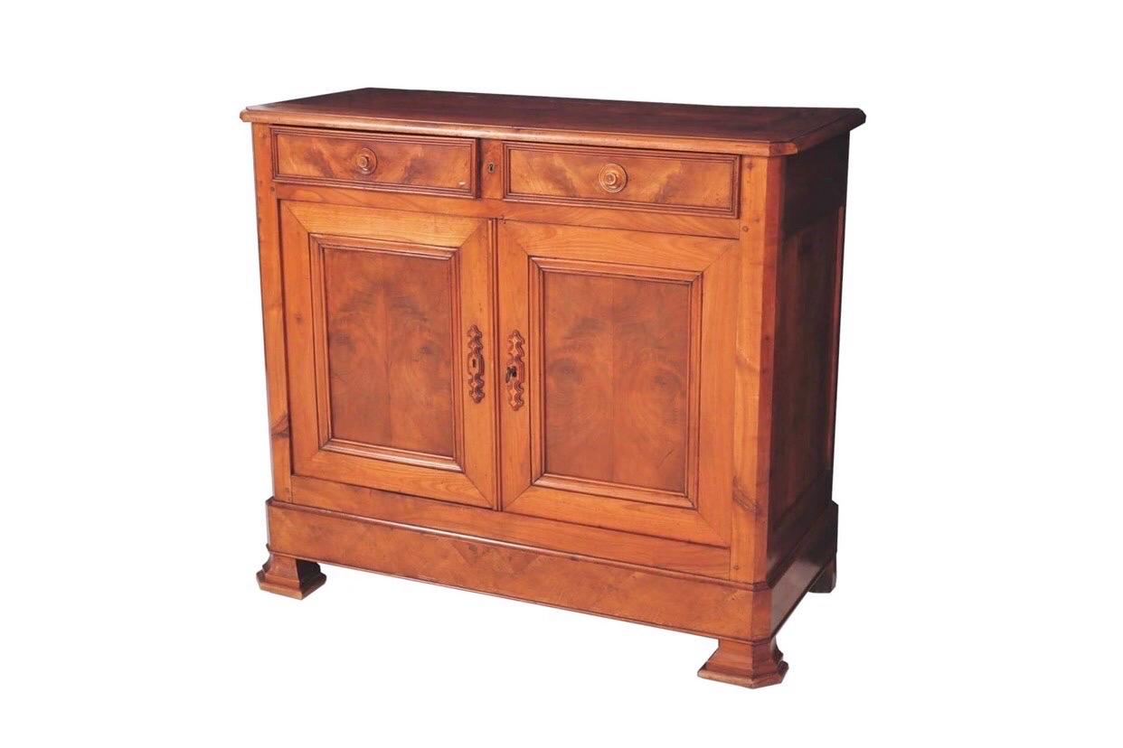 A Louis Philippe period buffet handcrafted in walnut. Two hand dovetailed drawers over cabinet doors are covered with bookmatched burled walnut panels. Inside is housed a single shelf and cabinet doors with bevelled escutcheons lock with the