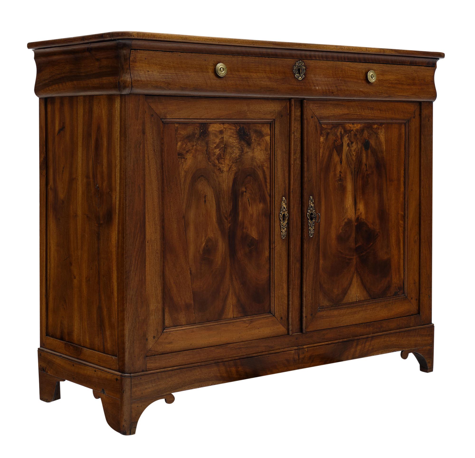 Buffet from France made of solid walnut and burled, figured walnut. There is one dovetailed drawer in the “doucine” apron, above two doors that open to reveal interior shelving. We love the beautiful wood and strong proportions.