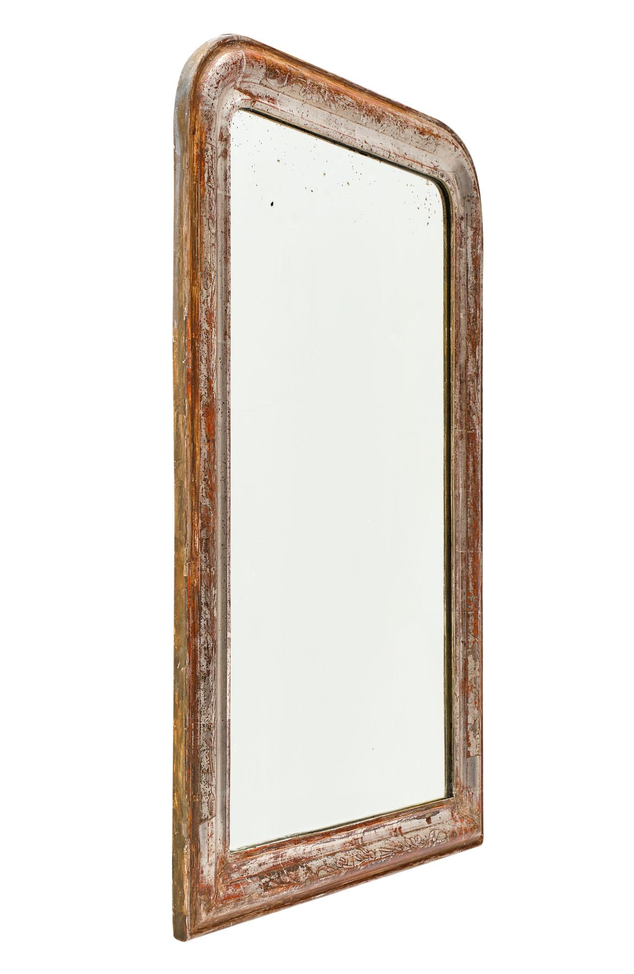 French Louis Philippe period mirror made of wood and gesso. The hand-chiseled frame has the original silver leaf and sienna colored glaze showing through. The heavy patina on this piece makes it especially warm and inviting.