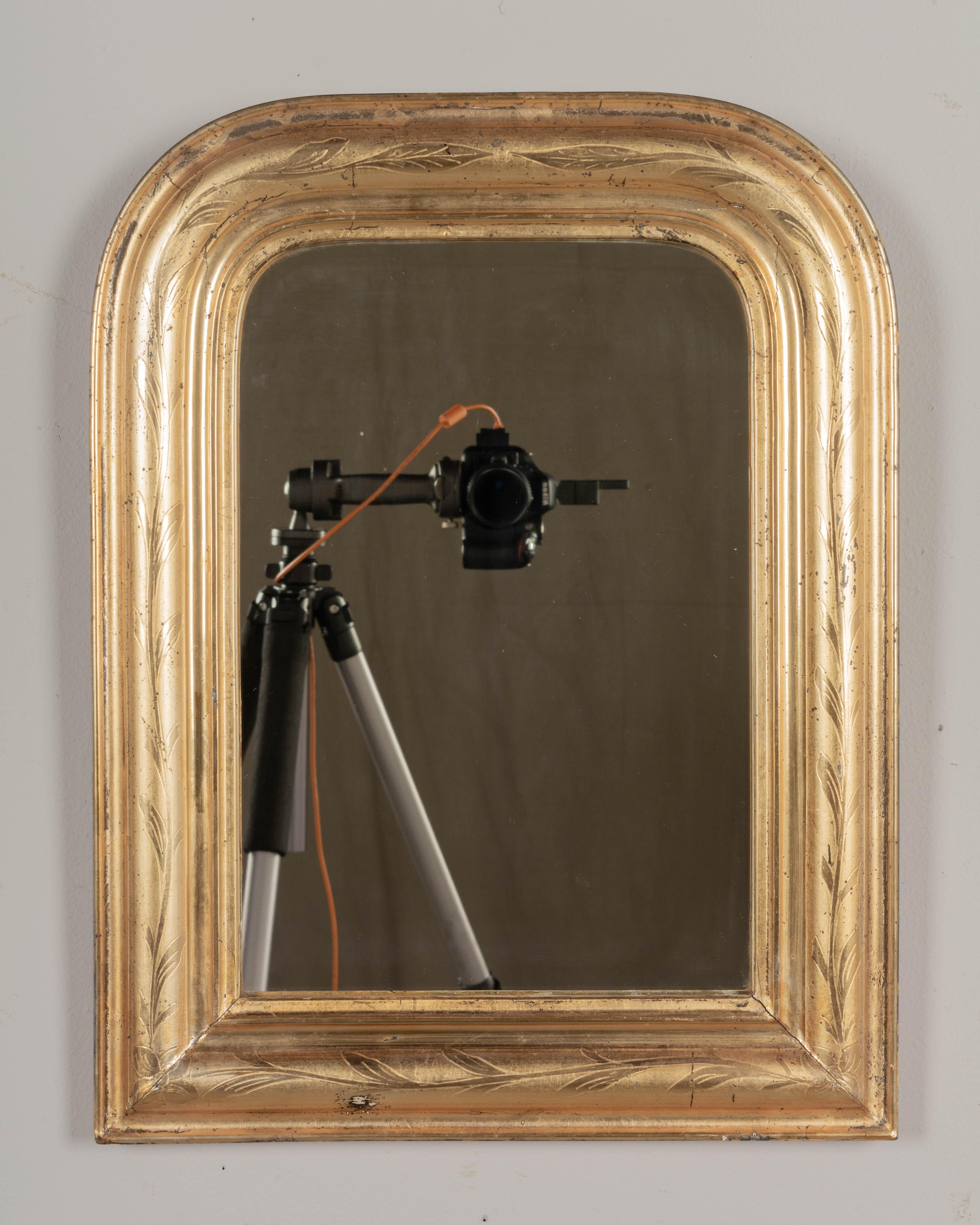 A small French Louis Philippe style giltwood mirror with curved top corners and incised leaf decoration. Original mirror. Bright gilt finish with minor losses. Please refer to photos for more details.
Overall dimensions: 15.75