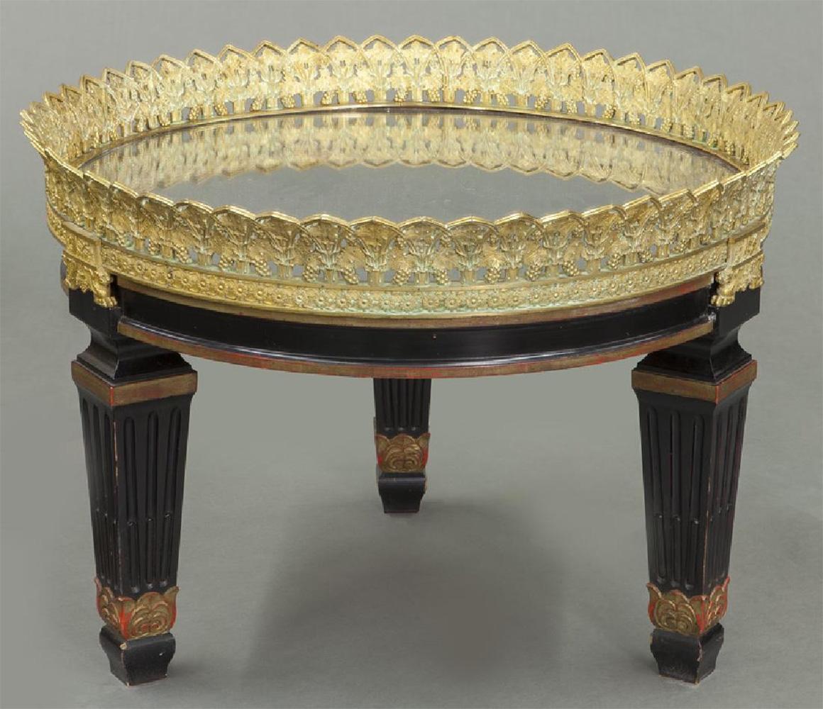 A fine Louis Philippe mirror topped coffee table with a tall ornate gilt-bronze lip surrounding the top decorated with grape clusters, leaves, sunflowers and winged lions, all raised on three tapered and fluted column ebonized legs with stylized