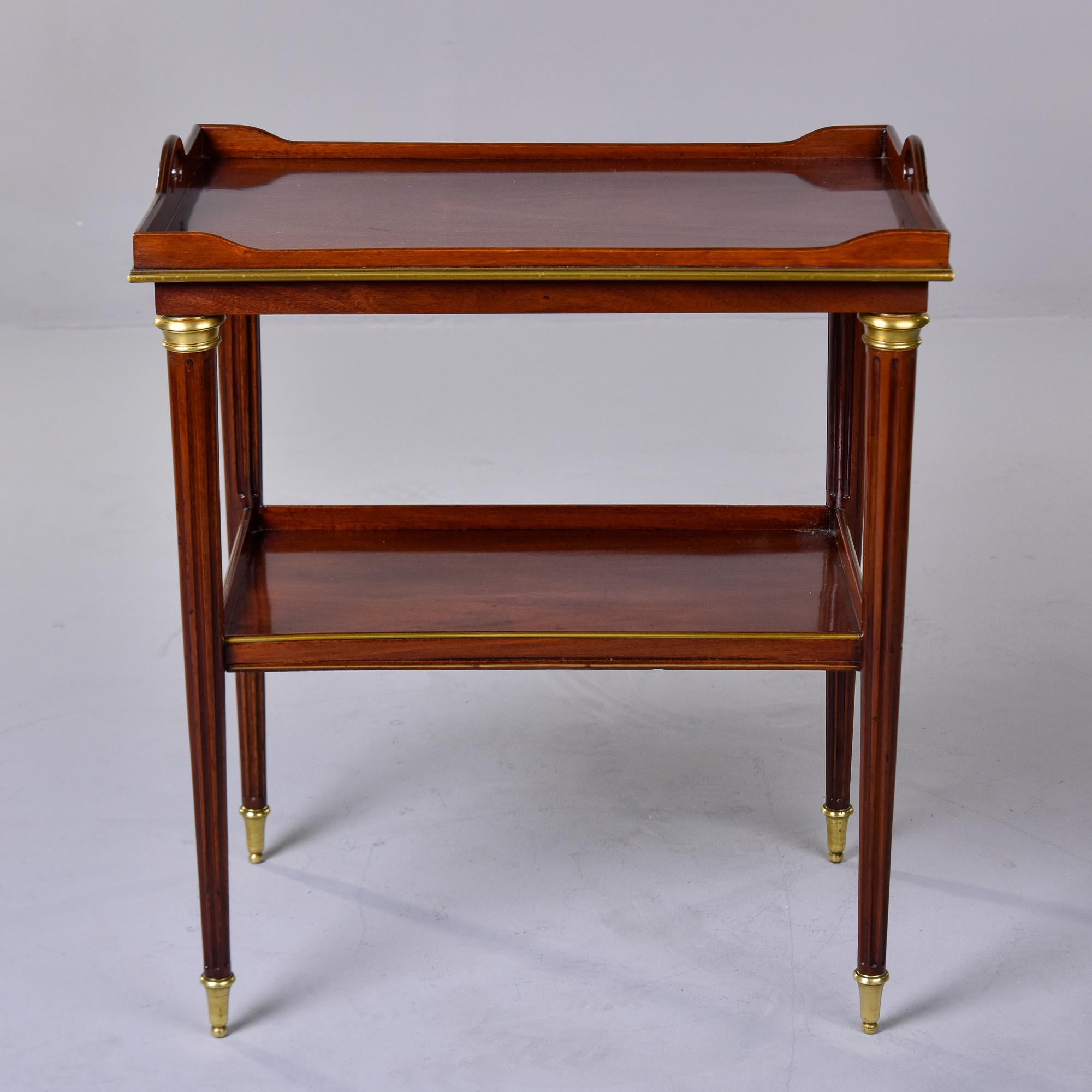 This French Louis Philippe style mahogany tray top side table dates from the 1930s. The top is shaped like a tray but does not lift off. Trimmed in brass at the base of the tray, top of the legs and the tapered, reeded legs have brass-capped feet.