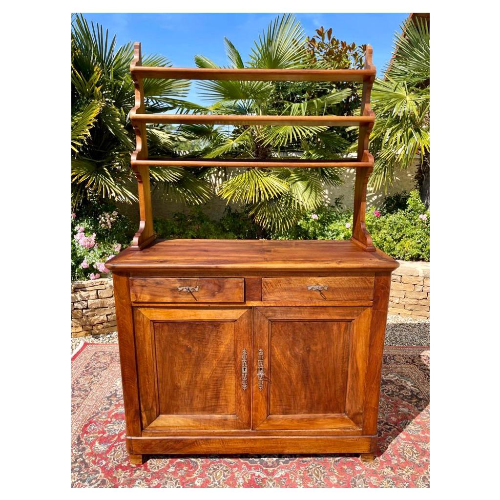 Louis Philippe style solid walnut dresser composed of two drawers and a cupboard with shelf. This piece of furniture is in good condition and has a very nice patina.