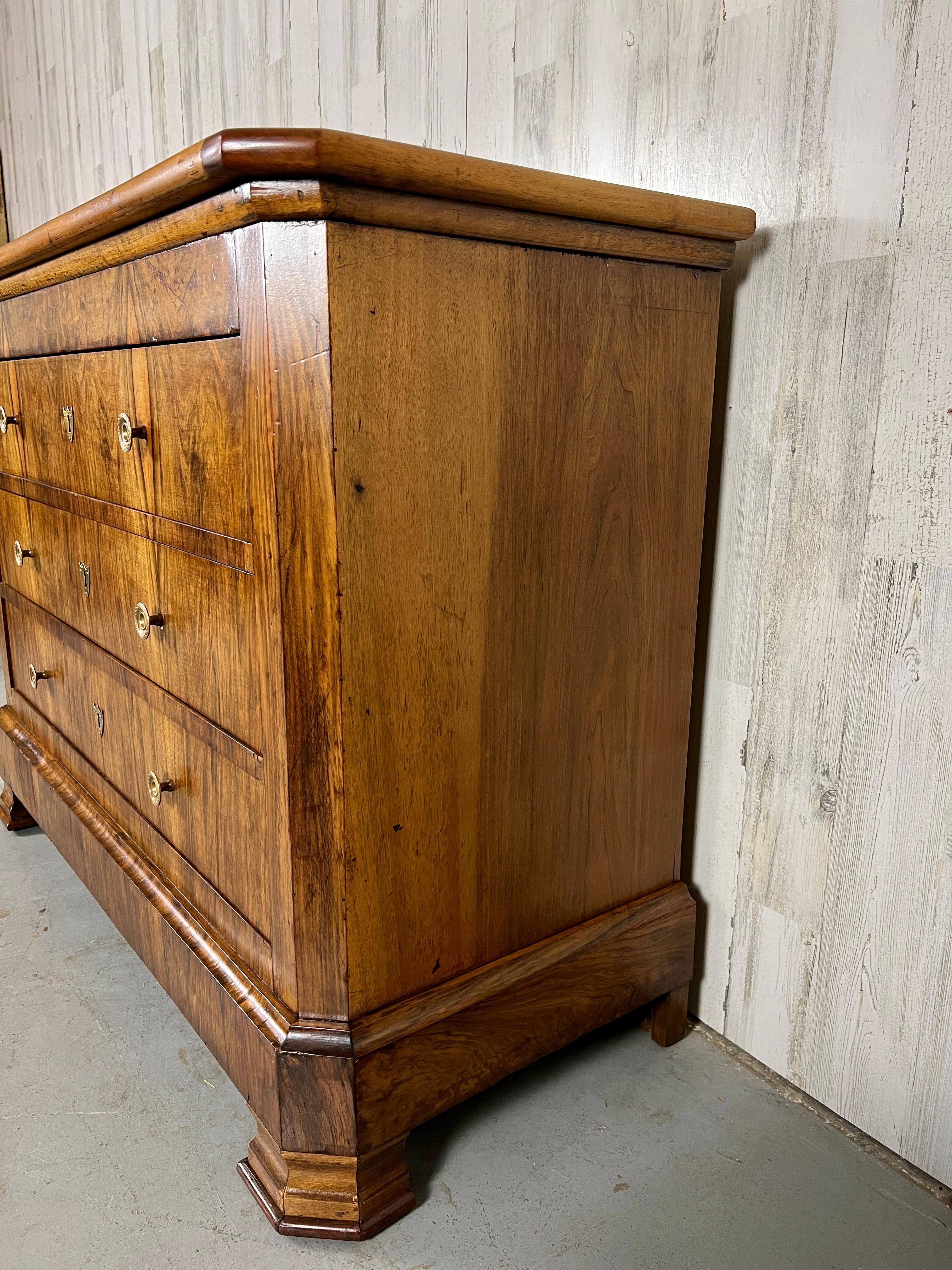 A Combination of Burled Walnut with wild cherry make this chest of drawers a stunning addition to any room. The brass pulls have a engine turned design that really adds to the overall appeal. The drawers were recently upholstered on the inside.