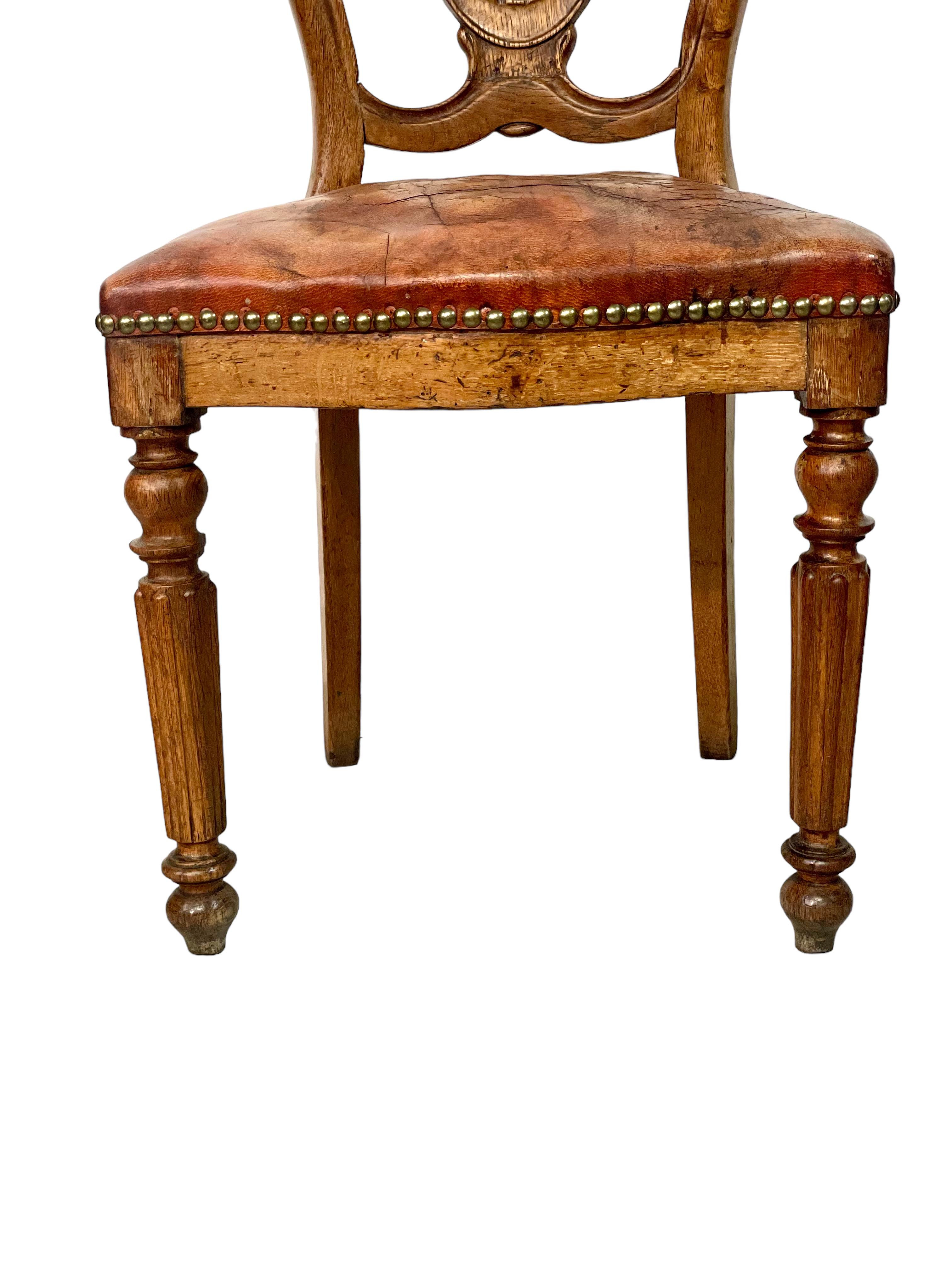 Questa bella poltrona Louis Philippe è realizzata in noce e pelle e presenta il profilo superiore arrotondato e la vita stretta del classico stile 