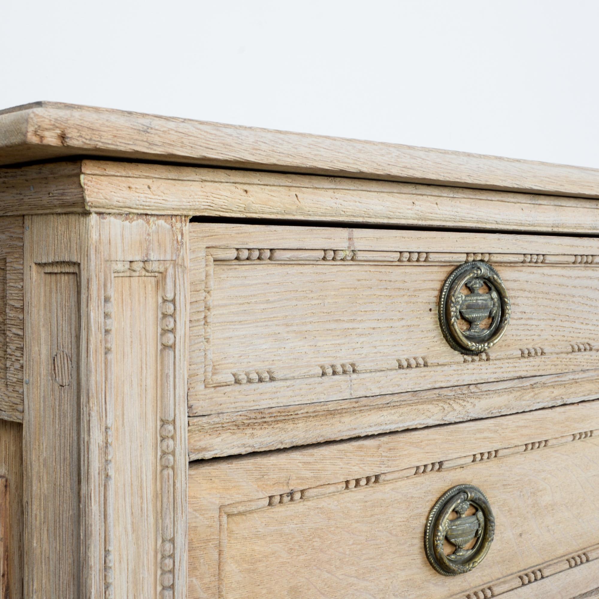 A five drawer oak chest in distinctive Louis Phillipe style, circa 1820. High quality construction is durable and beautiful. Carved details look fresh in bleached oak finish. Sporting brass casted hardware.