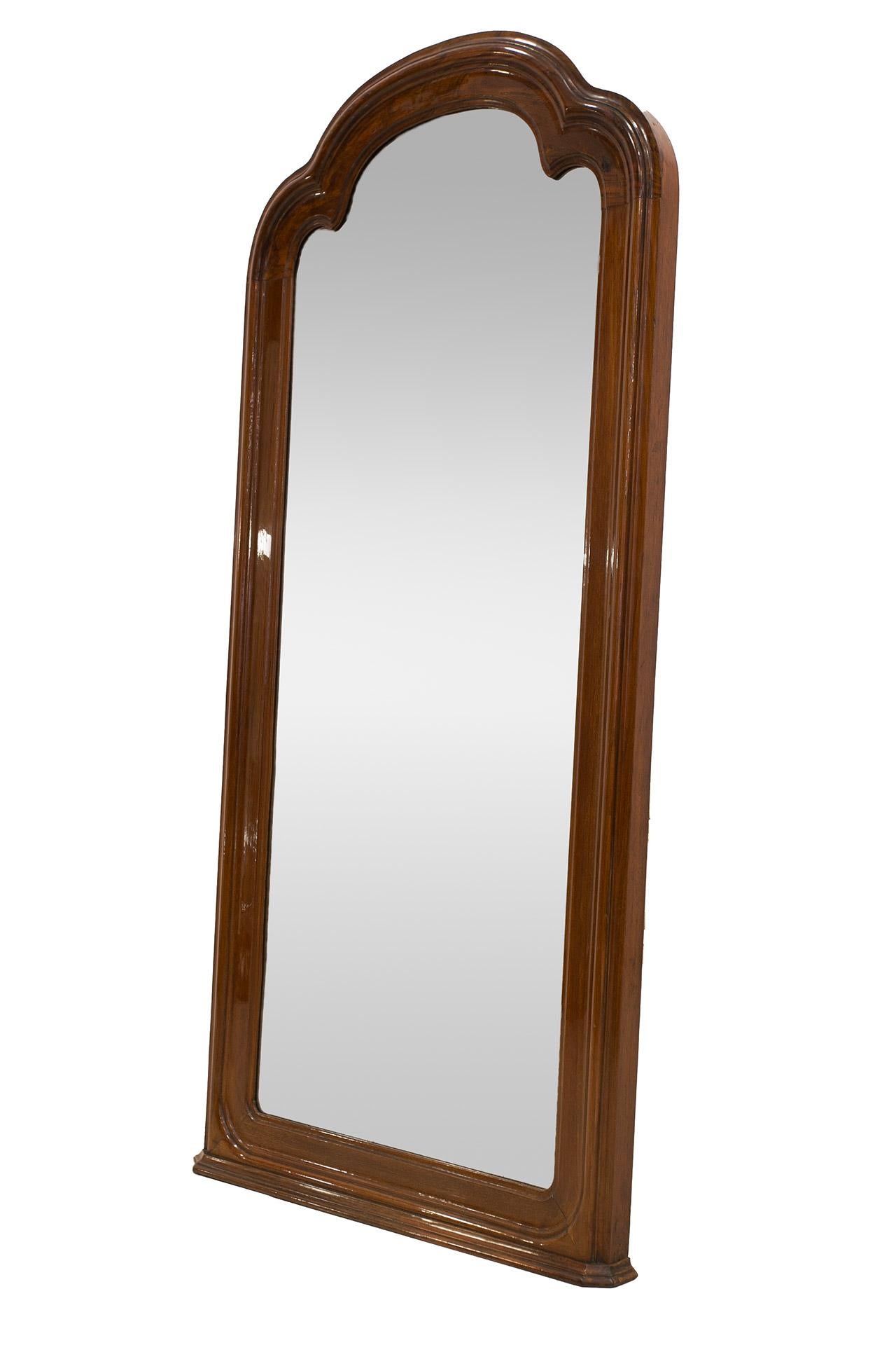 This mirror comes from the 1860s. The shape of the mirror is a rectangle, the top is crowned with a decorative arch. The profiled frame is made of a precious wood - mahogany, which was polished to a high gloss. The mirror can be hang or can be