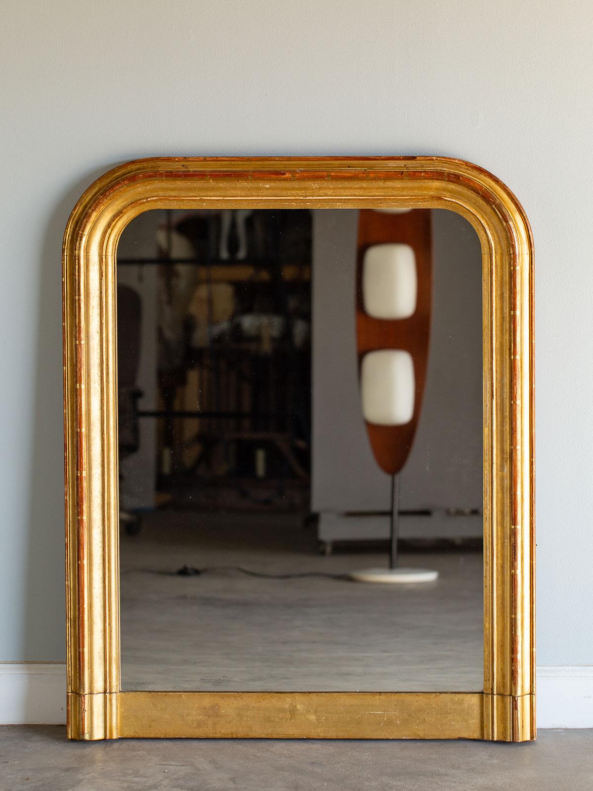 An antique French Louis Philippe gold mirror, circa 1885 with the original mirror glass and gold leaf detailing. Please be sure to enlarge the photographs to see the exceptional beauty of both the molding profile and the luminous beauty of the hand