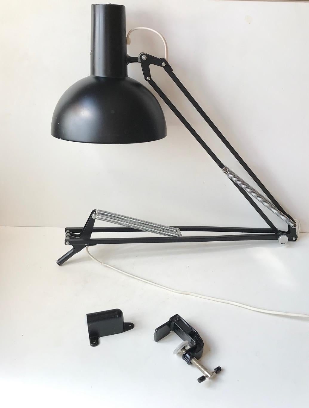 Often referred to as 'The Ghost of PH' and based on the Ideas of Poul Henningsen this fully adjustable black 'Anglepoise' desk or wall light was designed in-house at Louis Poulsen in the early 1970s. It comes with LP stickers and original porcelain