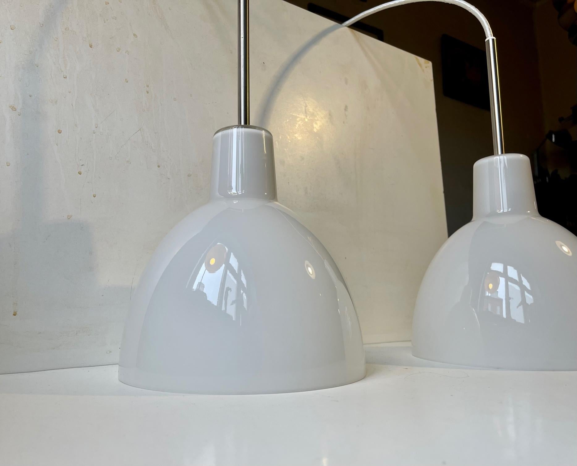 A pair of model 220 toldbod pendant lamps developed by the design team at Louis Poulsen in 1982 to the Customs Building (Toldboden) in Copenhagen. This design is based upon the elliptical reflector of PH - Poul Henningsen. This type of reflector