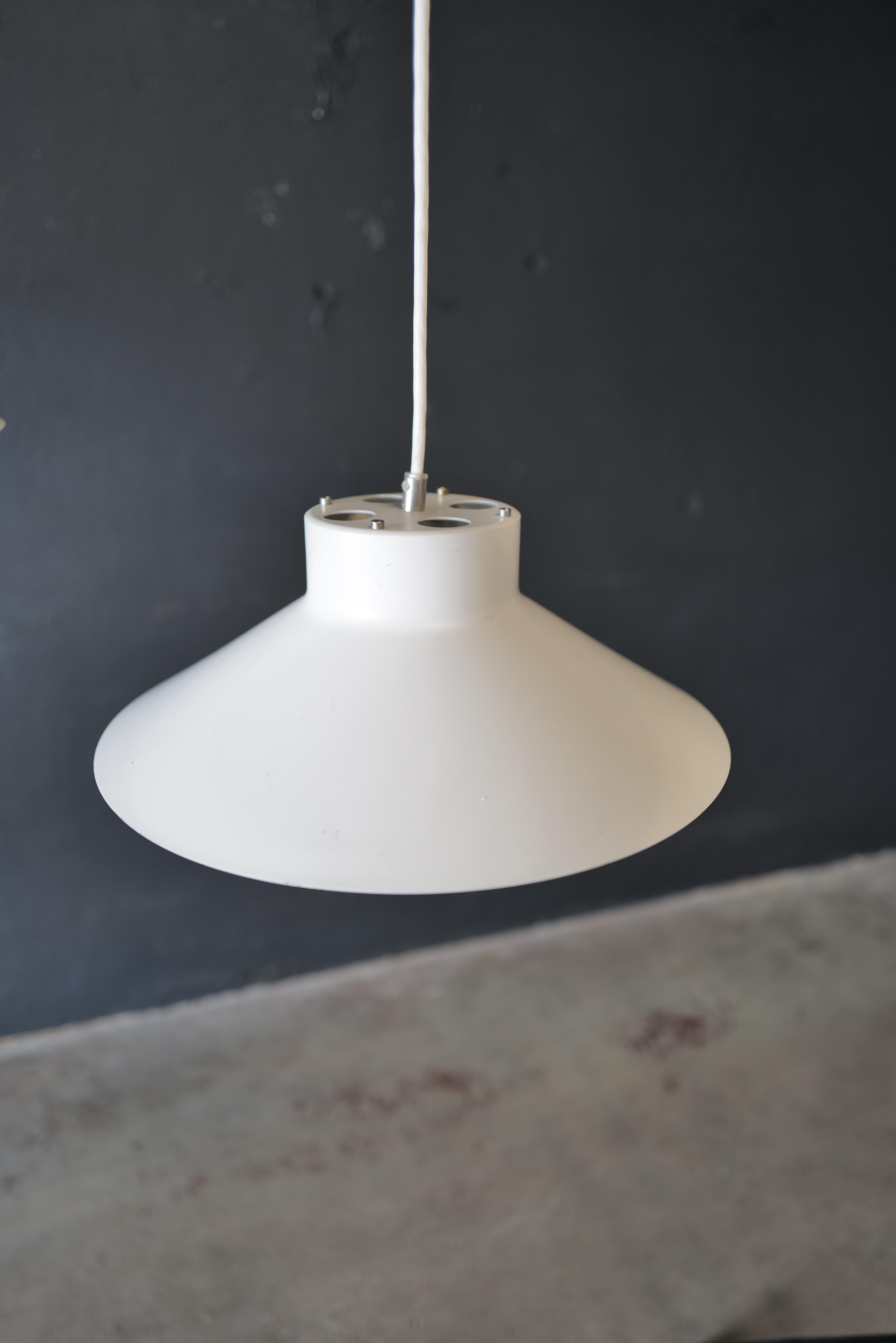 La lampe suspendue Louis Poulsen est un superbe luminaire connu pour son design intemporel et son exceptionnelle qualité d'exécution. Elle est dotée d'une Silhouette épurée et élégante, conçue pour éclairer les espaces de manière à la fois