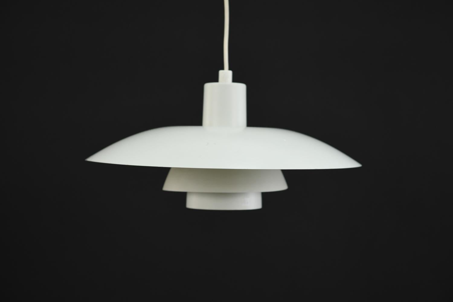 This pendant light was designed was Poul Henningsen for Louis Poulsen as part of Henningsen's groundbreaking three shade system that uses metal shades to direct uniform, downwards lighting. This model PH4/3 pendant light has a clean, modern look