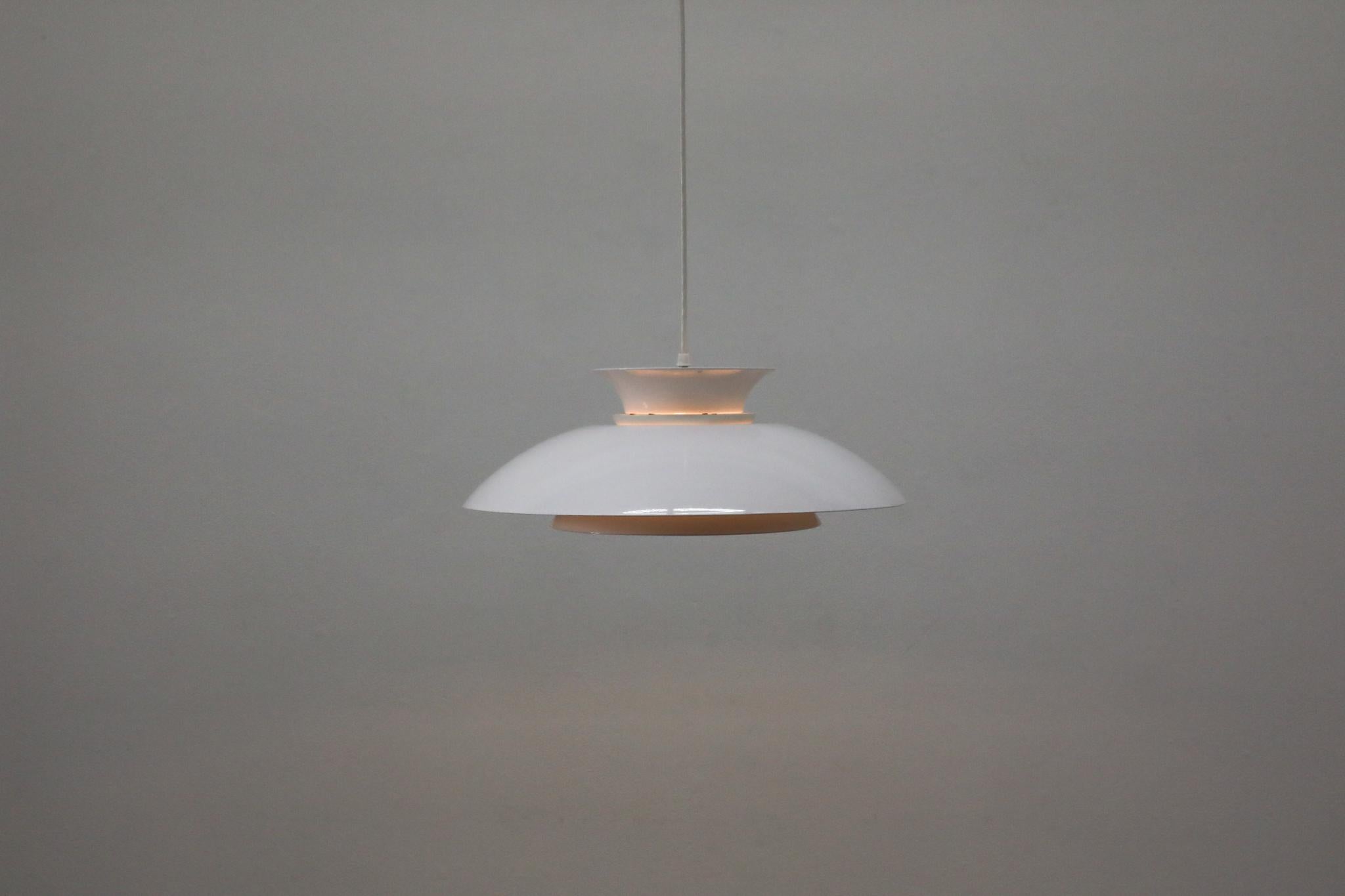 Pendentifs classiques de style Louis Poulsen, incarnant les principes de conception emblématiques de Poul Henningsen. Chaque luminaire est doté d'un abat-jour bombé simple et élégant en aluminium émaillé blanc, une forme qui a défini le modernisme