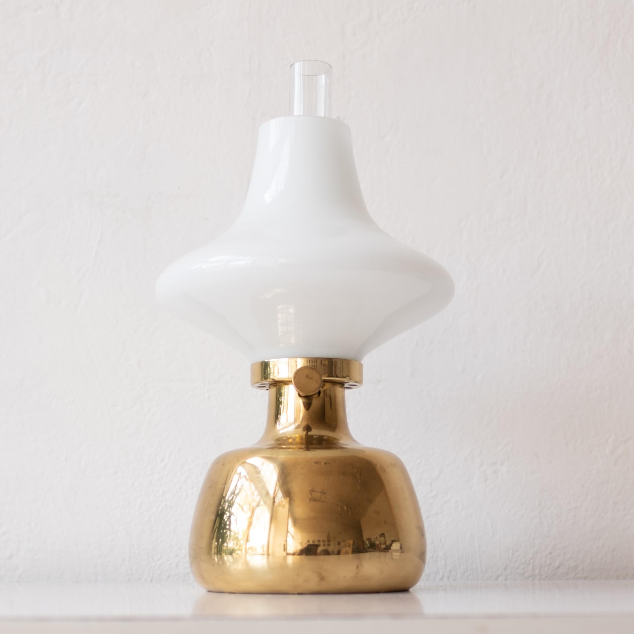 Designed by Henning Koppel and manufactured by Louis Poulsen. The Petronella oil/kerosene table lamp is made from solid brass and has a glass shade.