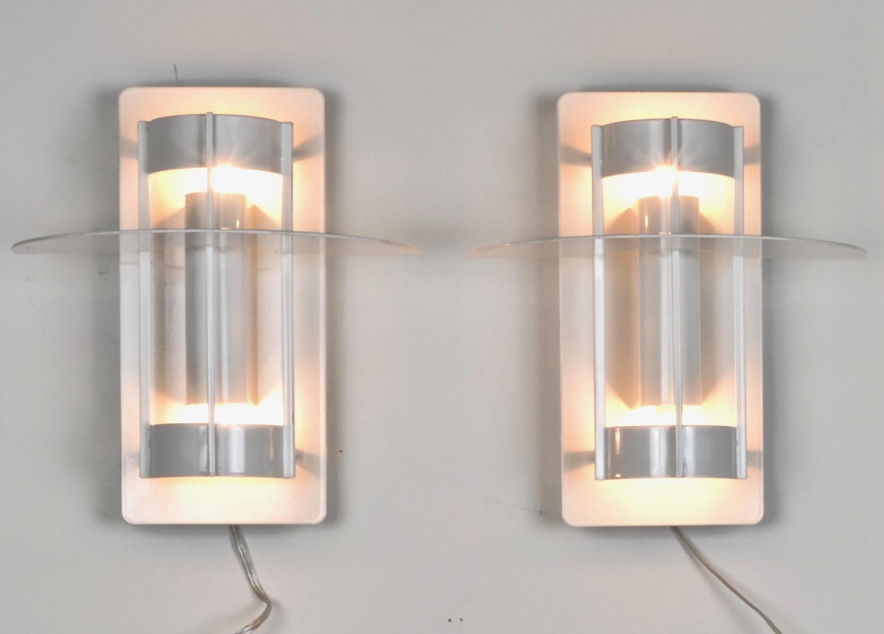 A pair of these modern classic sconces designed by Louis Poulsen. Each newly wired, replacing original florescent fittings with incandescent lights. Single bulbs facing up and down. Very nice quality fixtures. Powder-coated in gloss white. 