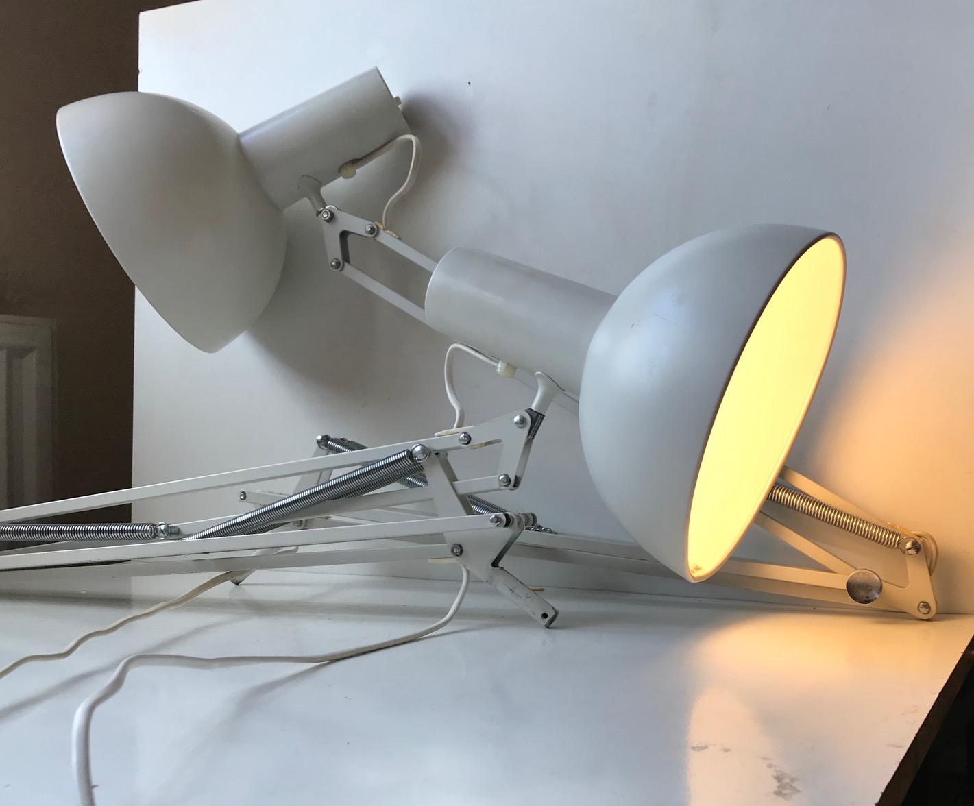 Often referred to as 'The Ghost of PH' and based on the Ideas of Poul Henningsen these fully adjustable white 'Anglepoise' desk or wall lights was designed in-house at Louis Poulsen in the early 1970s. Both with early LP stickers to the inside of