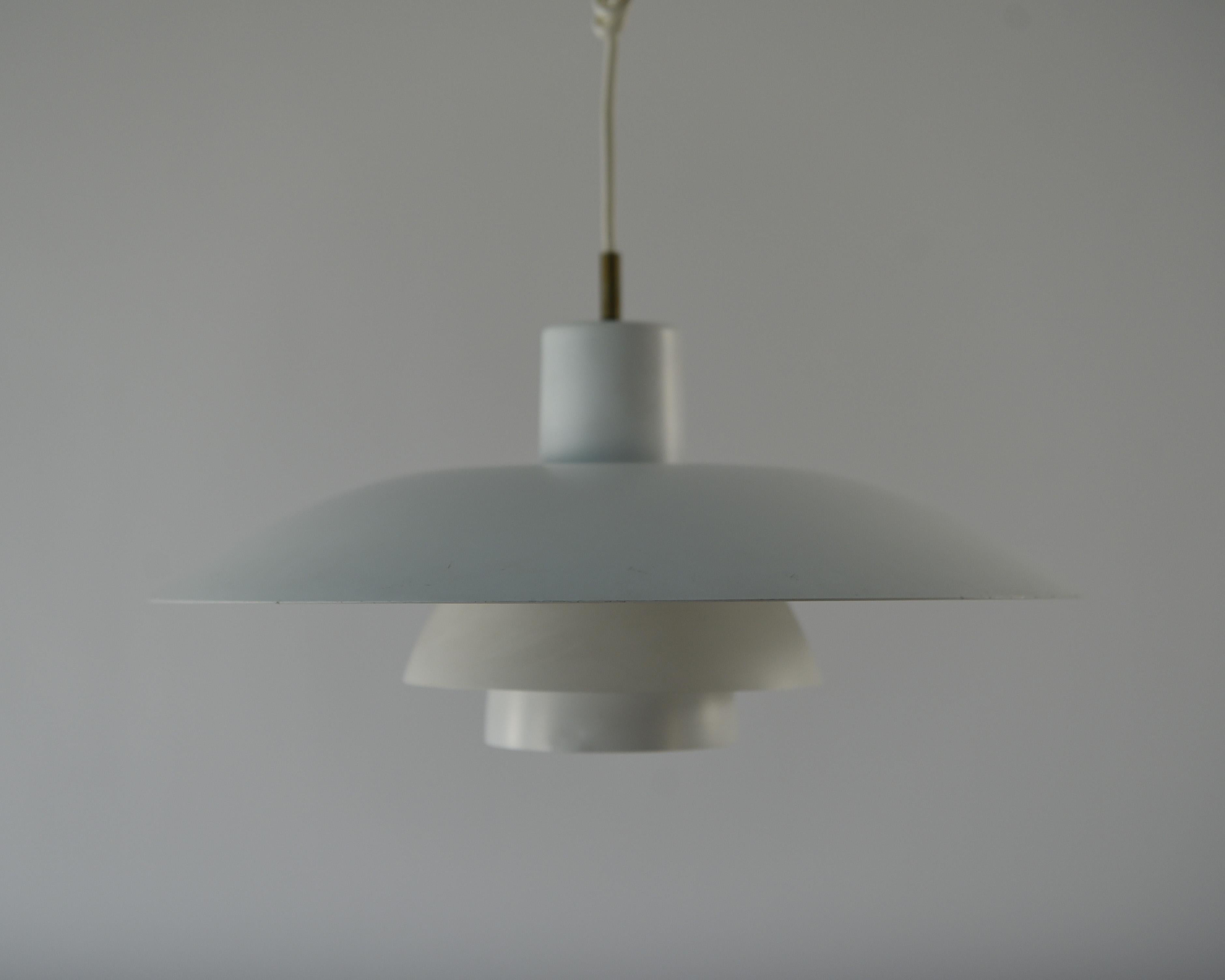 This PH4 lamp was produced in the 1950s by Louis Poulsen and designed by Poul Henningsen. This pendant light features layered shades to soften and disperse light effectively, a design fundamental to Henningsen's goal. As this lamp is in a simple