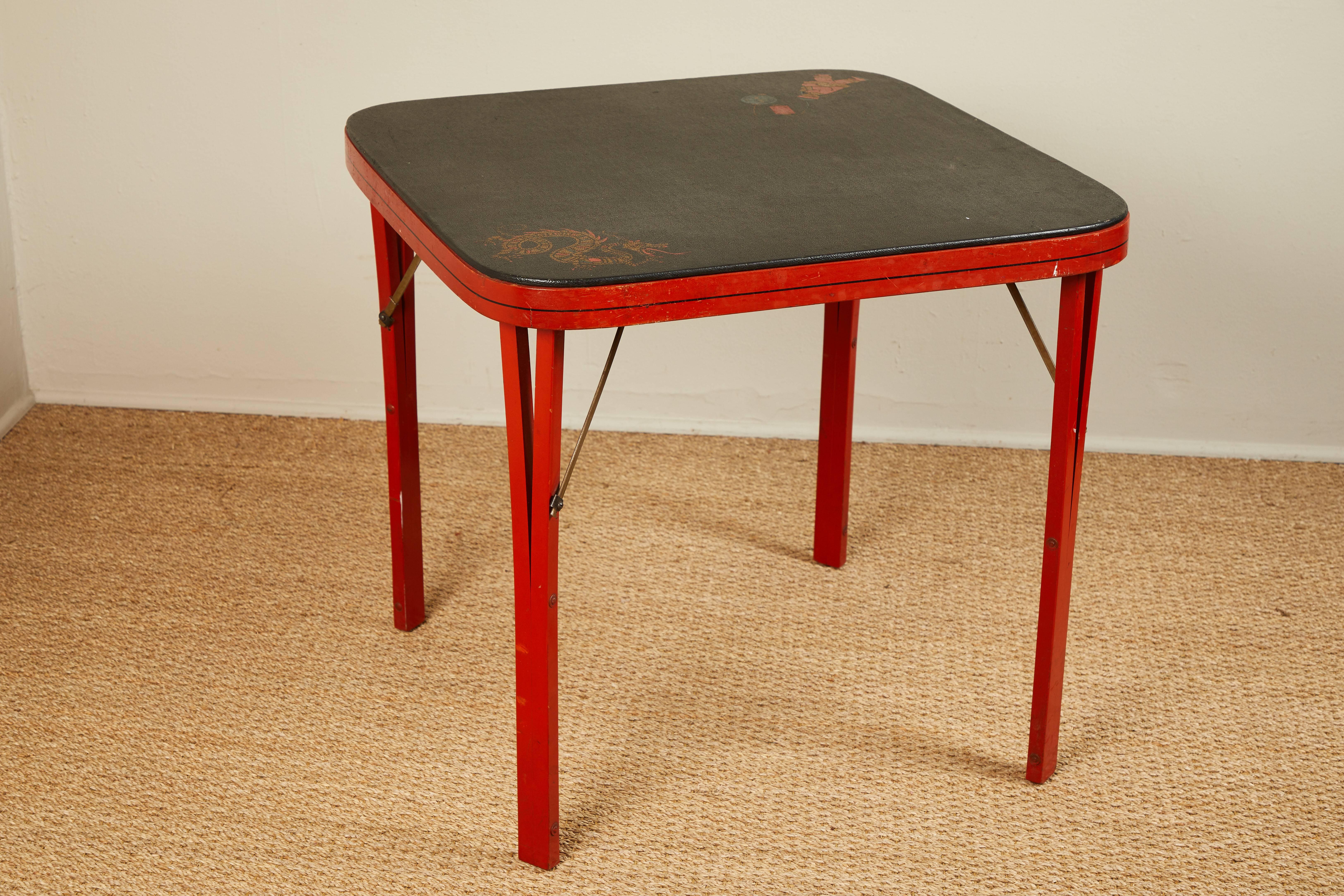 These sets were made in Indiana during the 1920s. This one might be for Mahjong as it has Chinese designs on the faux leather tabletop and three of the chairs. Chinese red with red, gold and green dragons. All the furniture folds.
 