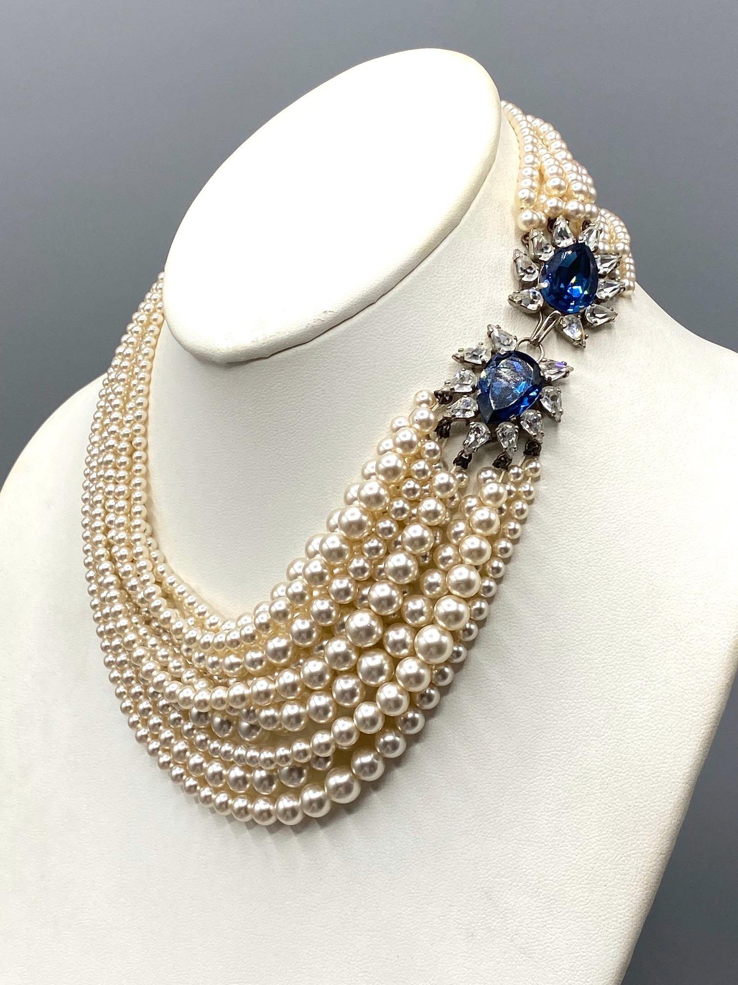 A beautiful French made faux pearl necklace with rhinestone clasp attributed to Louis Rousselet. The necklace has beautiful designs of 11 strands of graduated glass bead faux pearls with a striking rhinestone hook and eye clasp. Each side of the