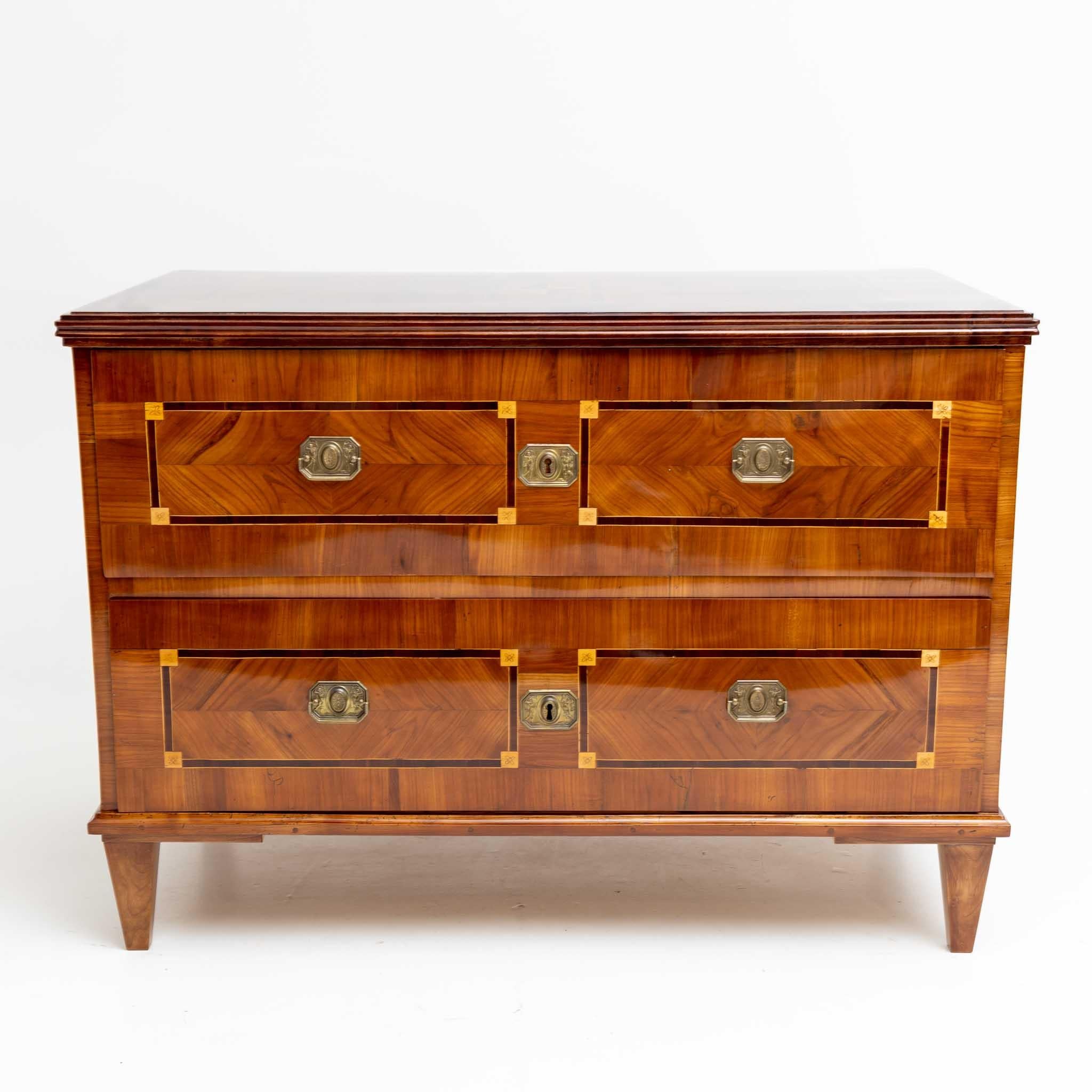 Louis Seize chest of drawers with two drawers and square pointed feet. The chest of drawers is veneered in cherry and has framing decorations on the surfaces. The chest of drawers has been professionally restored and polished by hand.