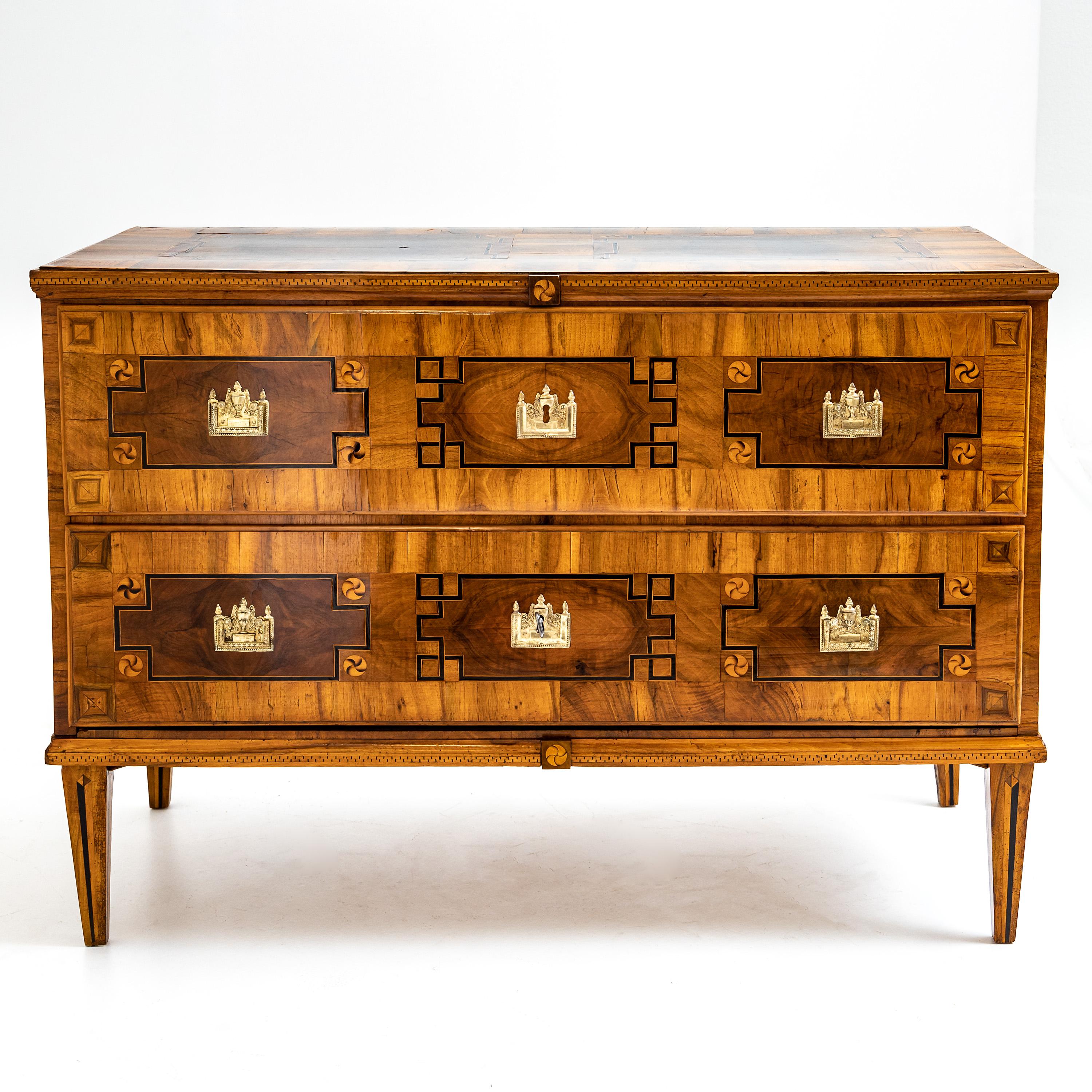 Two-drawer Louis Seize chest of drawers on square pointed feet. The commode shows beautiful marquetry and bronze fittings in amphora form. The chest of drawers was expertly refurbished and hand polished.