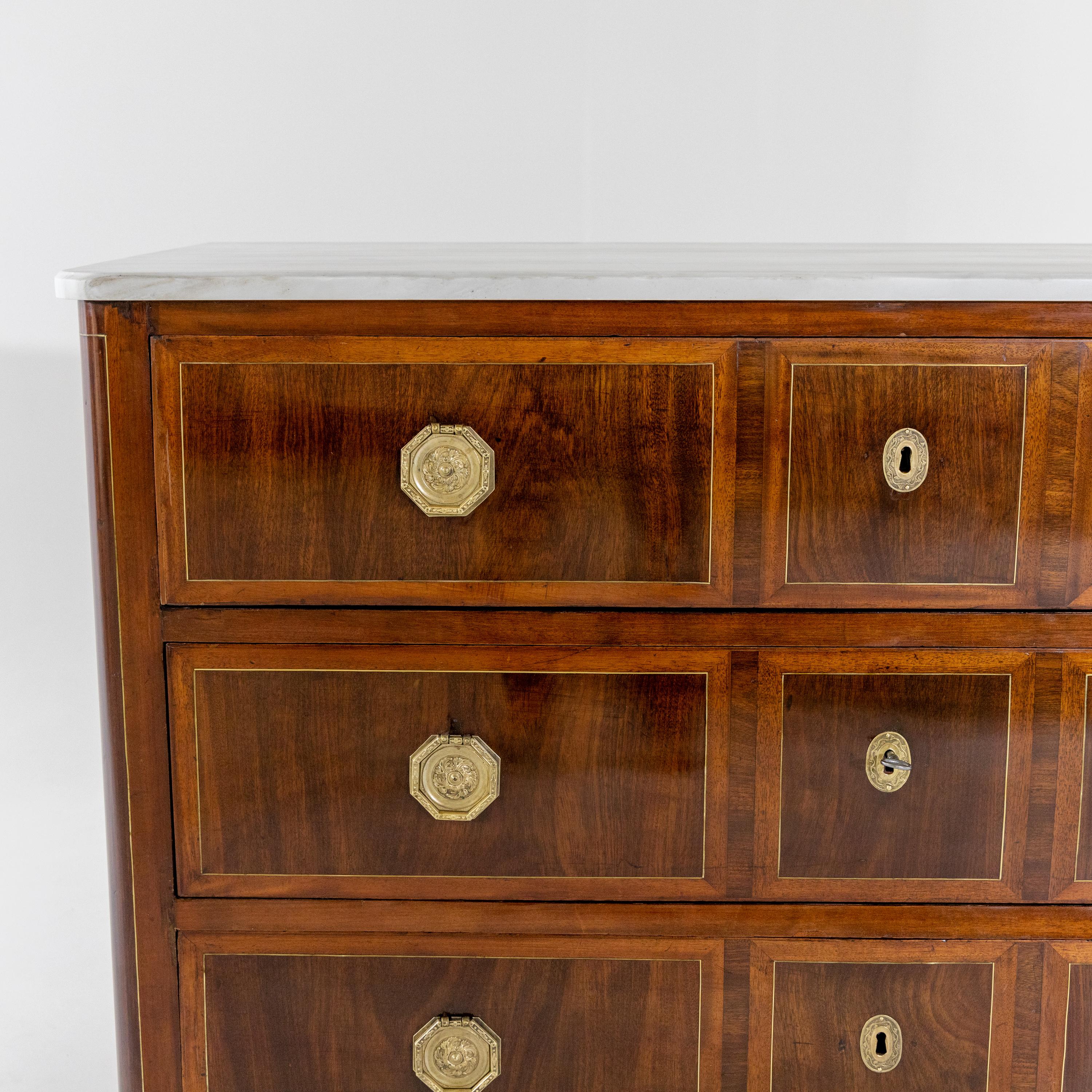 Chest of drawers with three-bay body and framing brass inlays on the sides and front. The top plate made of marble is recent.