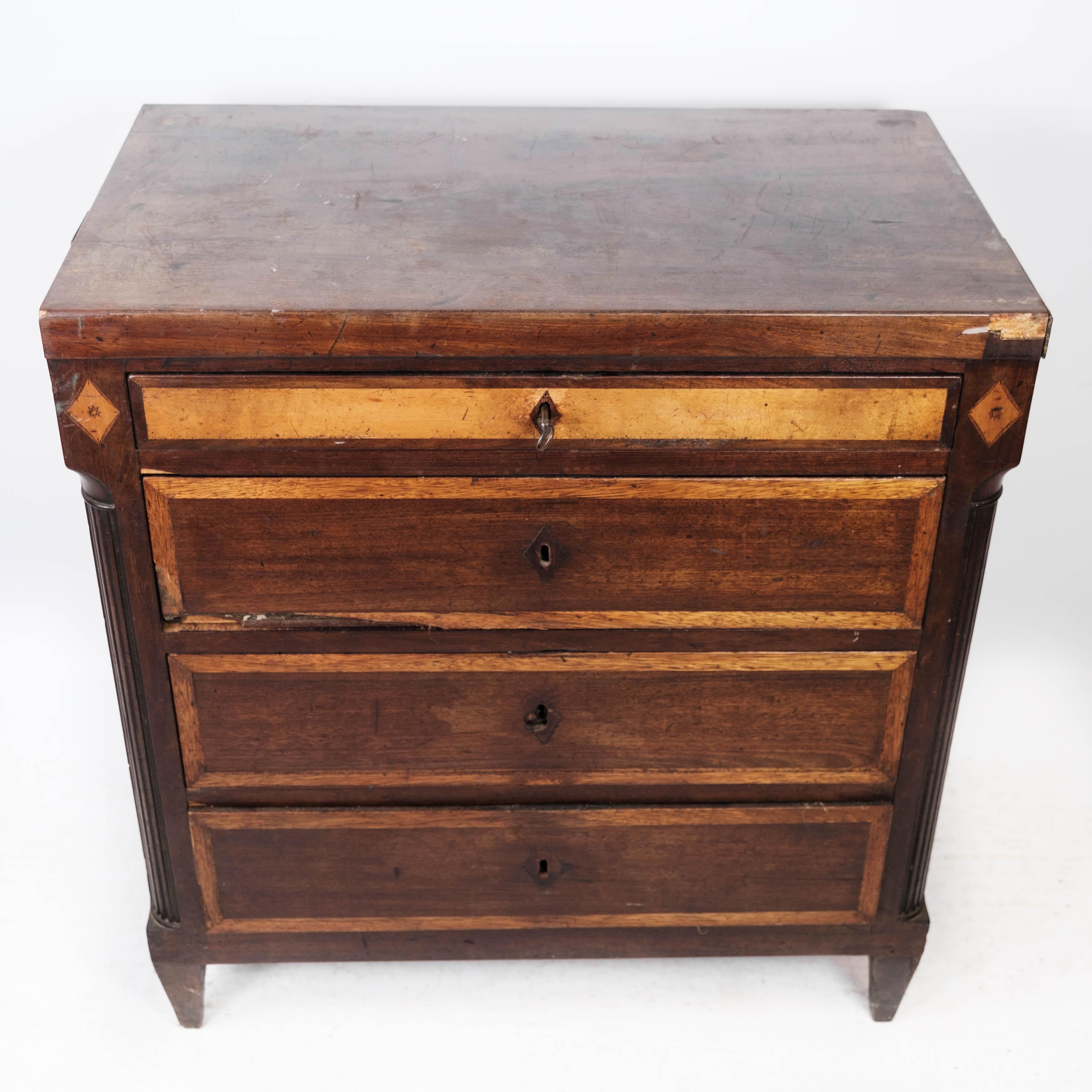 The Louis Seize chest of drawers, crafted from mahogany and adorned with exquisite inlaid wood detailing, is a remarkable antique piece from the 1790s. This elegant chest showcases the opulence and sophistication of the Louis Seize (Louis XVI)