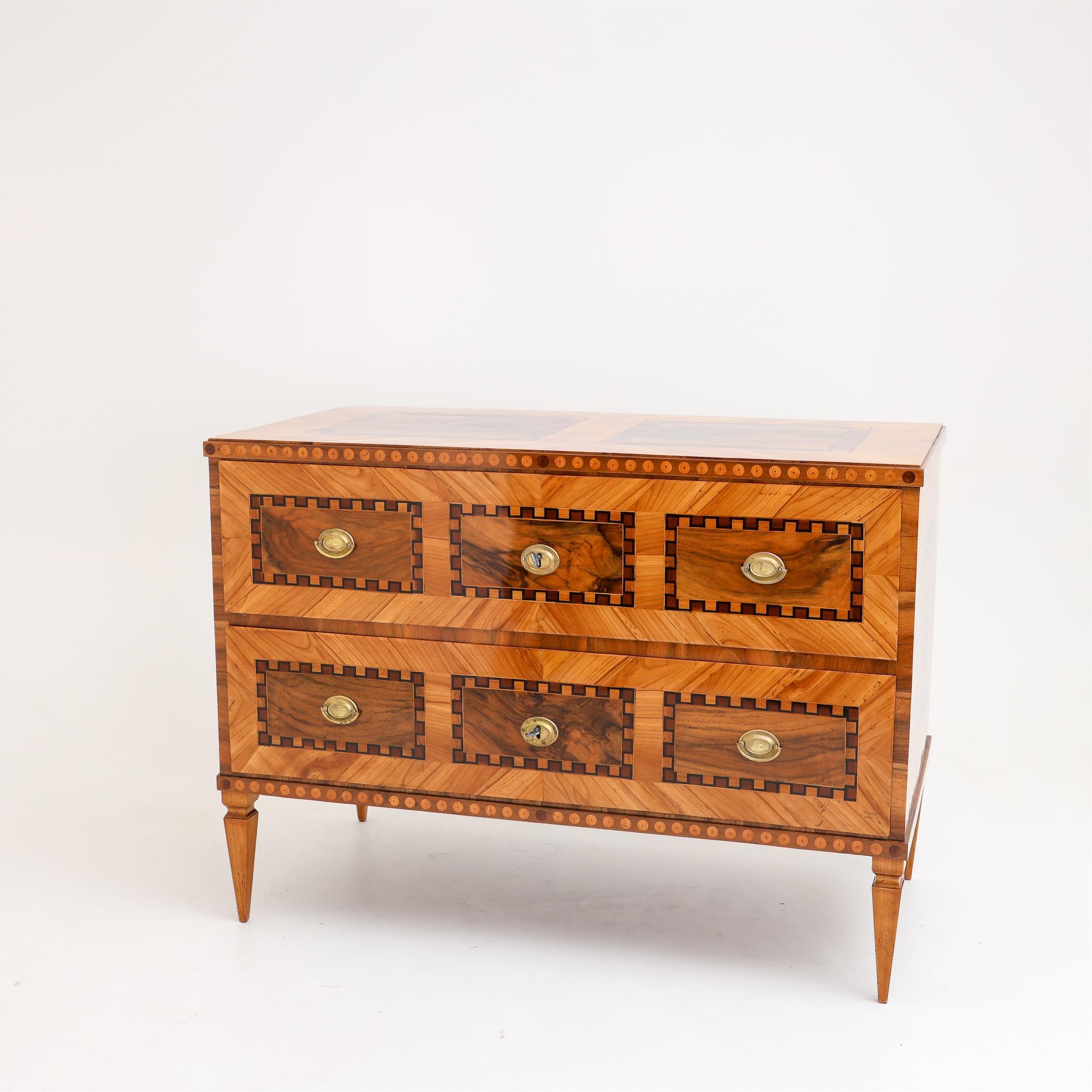 Louis Seize chest of drawers on square tapering feet with two drawers. Framing marquetry work on all sides. The chest of drawers has been professionally restored and hand polished.