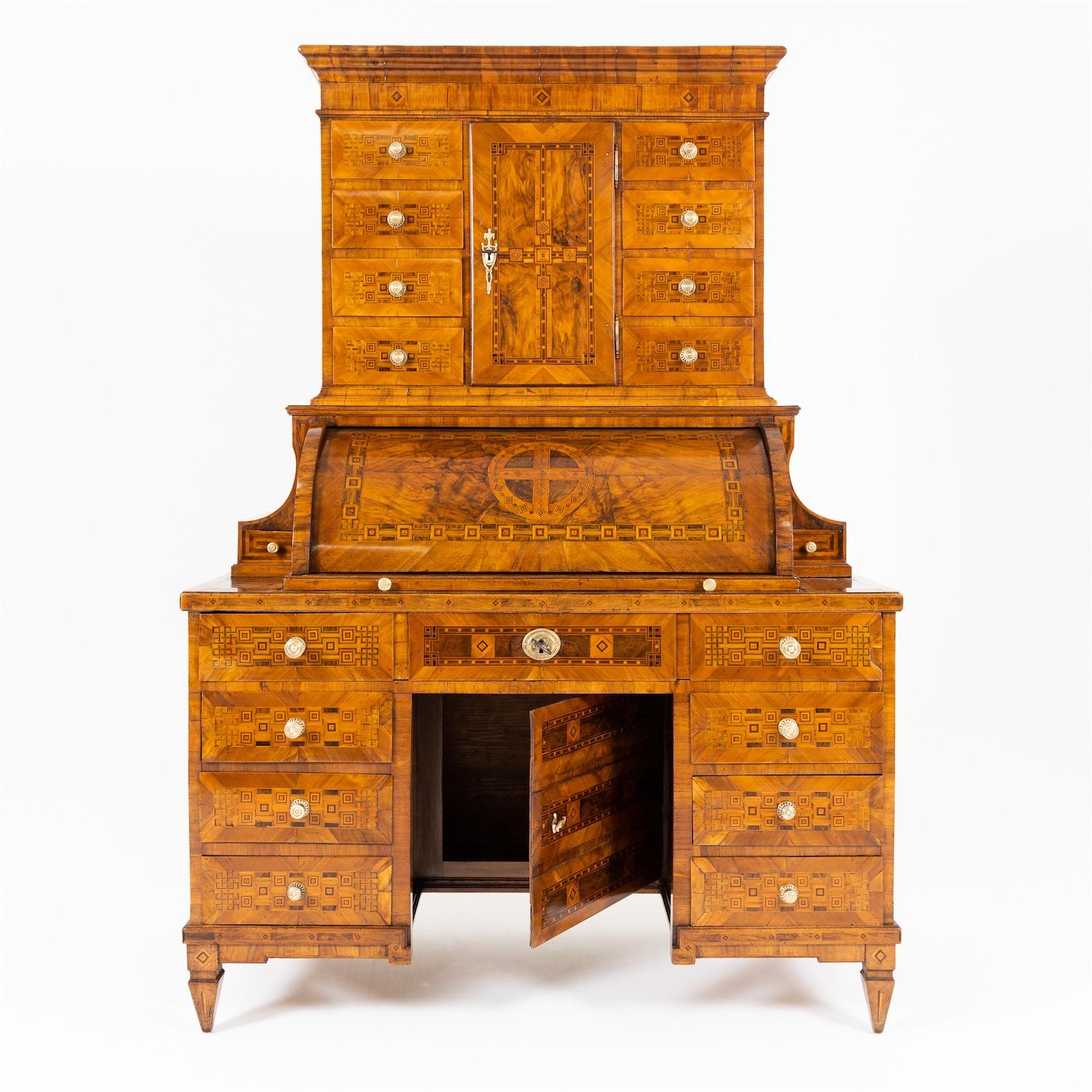 Louis Seize secretaire with square pointed feet and three-quarter cylinder door as well as a high top with straight profiled cornice, a tabernacle compartment and eight further drawers. The roll top door is flanked on the sides by concave elements