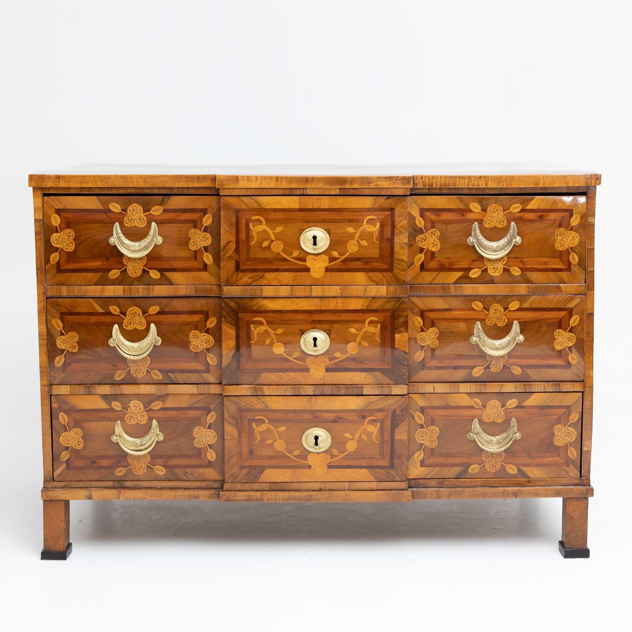 Louis seize chest of drawers with three drawers and rectilinear body with central risalit. The chest of drawers stands on socketed square feet and shows half-moon shaped fittings on the front. The chest of drawers is richly marked on all sides with