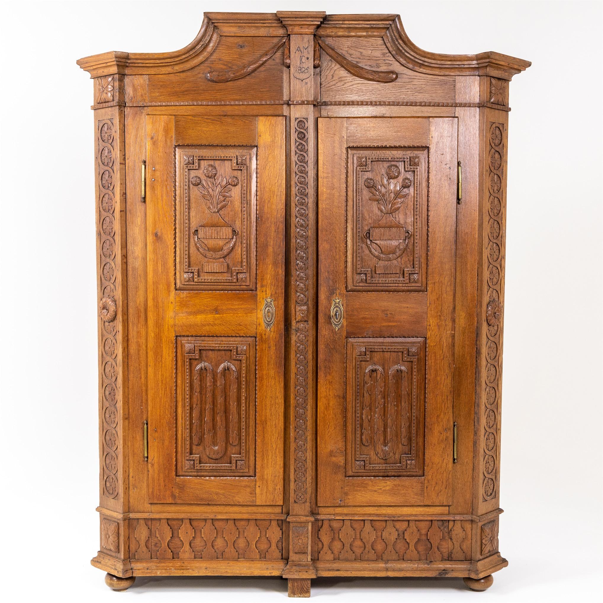 A two-door Louis Seize cabinet with chamfered pilasters and coffered doors and sides and a central raised moulded cornice. The pilasters and the striking moulding is decorated with carved interlace band motifs and accentuated at half height by