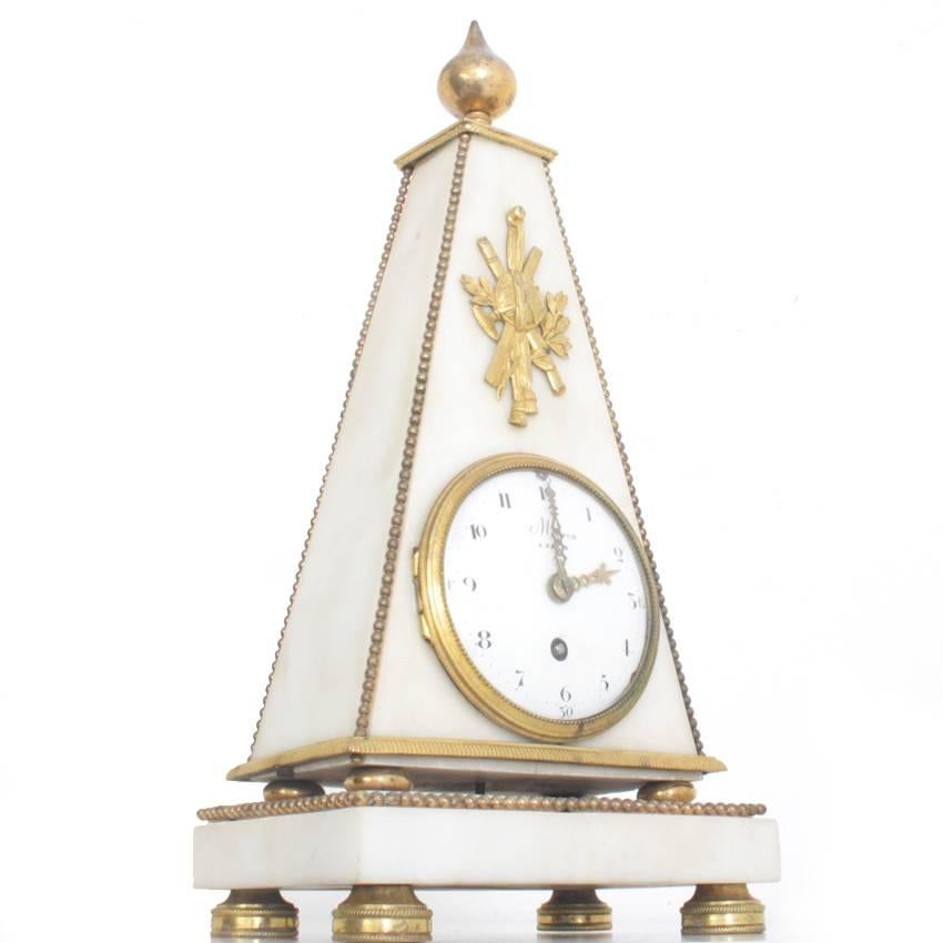 Pendule clock with a pyramid shaped marble body and guilt bronze fittings. The enamel clock face is signed Meuron à Paris.