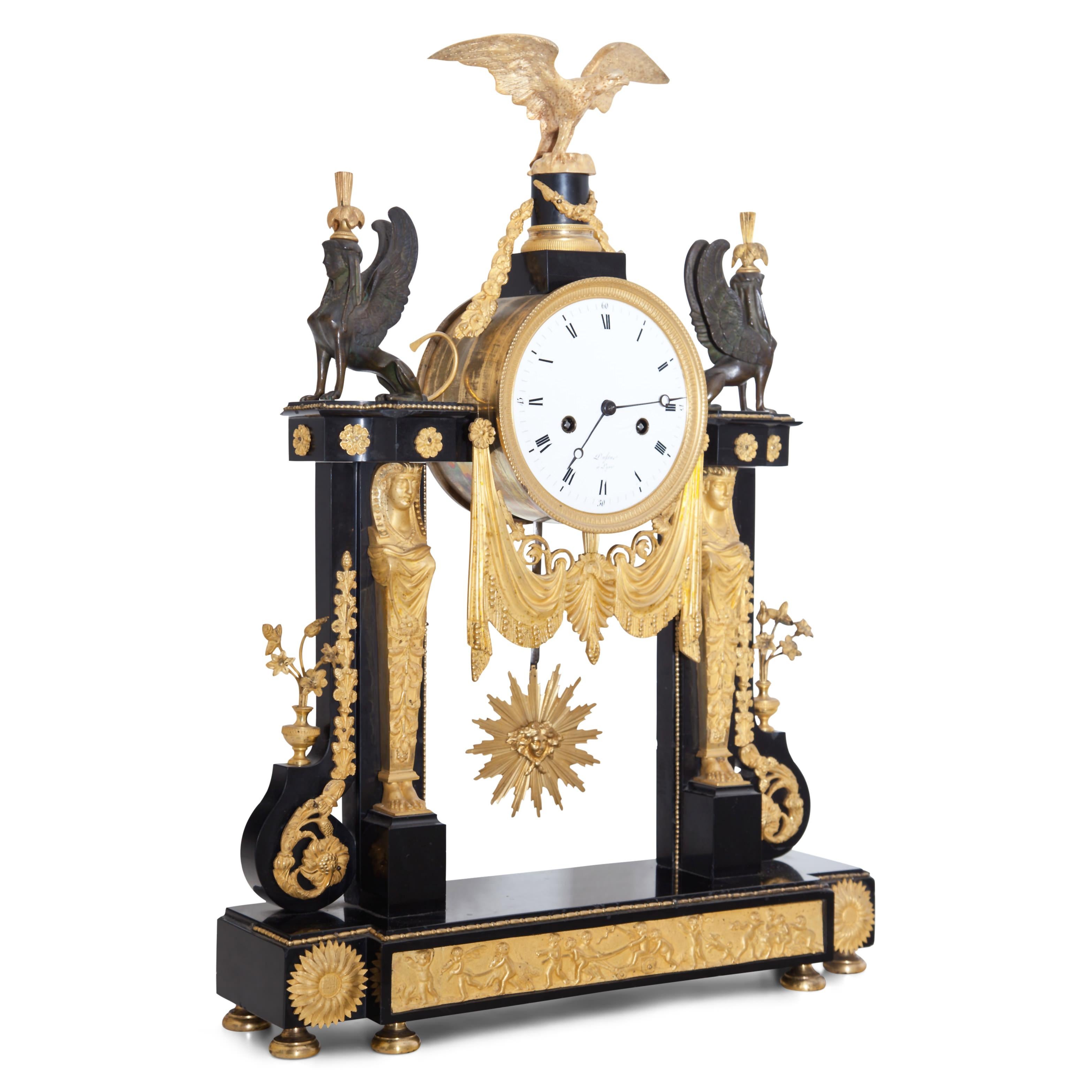 Louis Seize portal clock with eagle and sphinx decoration as well as Egyptian herms and frieze with putti on the base. Black marble and fire-gilded bronze. The work signed Dufue à Lyon. 


 