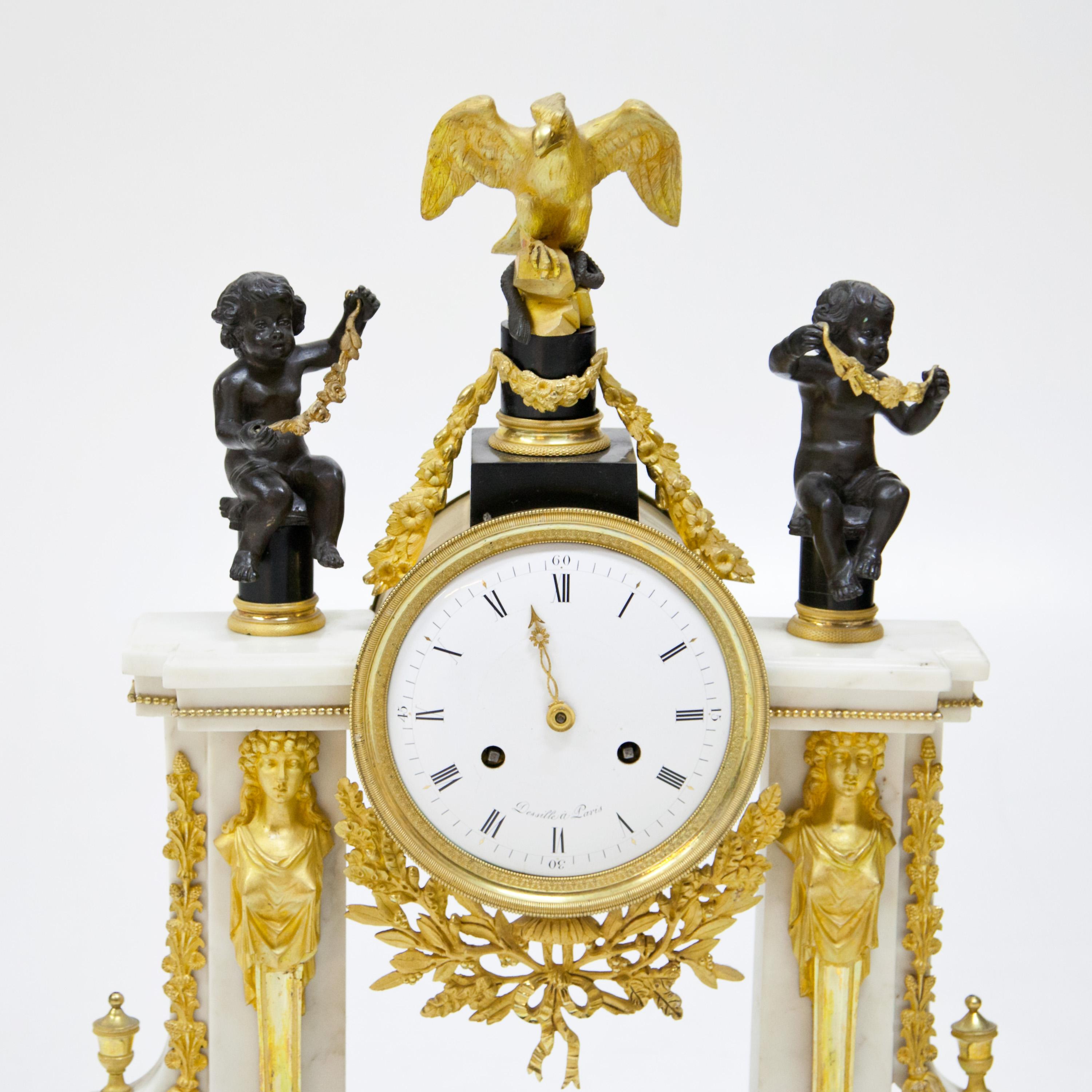 Louis Seize portal clock with fully plastic eagle and putti decoration. The portal is flanked by caryatids and the volutes are decorated with urns and garlands in fire-gilded bronze. The clock has a contrasting design with a portal in white and a