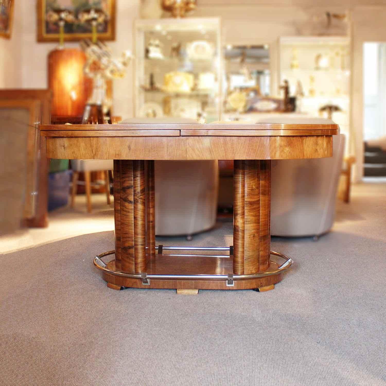An Art Deco extending table in figured walnut with slide out, straight grain walnut leaves. Chromed metal footrest to base. Set over thick reeded, demilune pedestals on an oval base.

Designer: Louis Sognot (1892-1970)

Dimensions: H 78cm, L