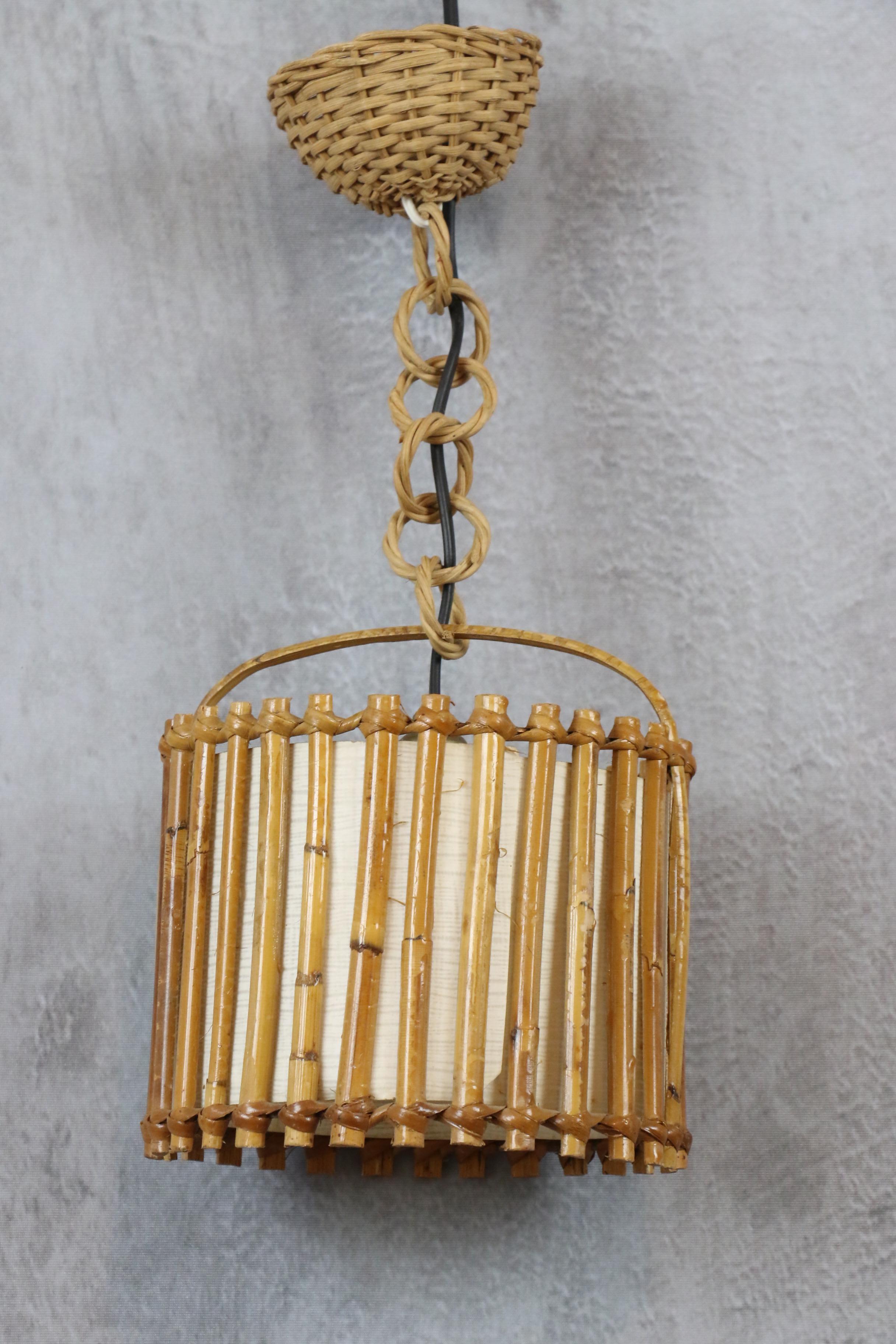 Louis Sognot Bamboo and Rattan Chandelier Mid Century Modern 1960, France

This lantern features a beautiful design with a spherical rattan structure.
It has a paper shade inside to diffuse a soft, warm light. It is suspended from a rattan link