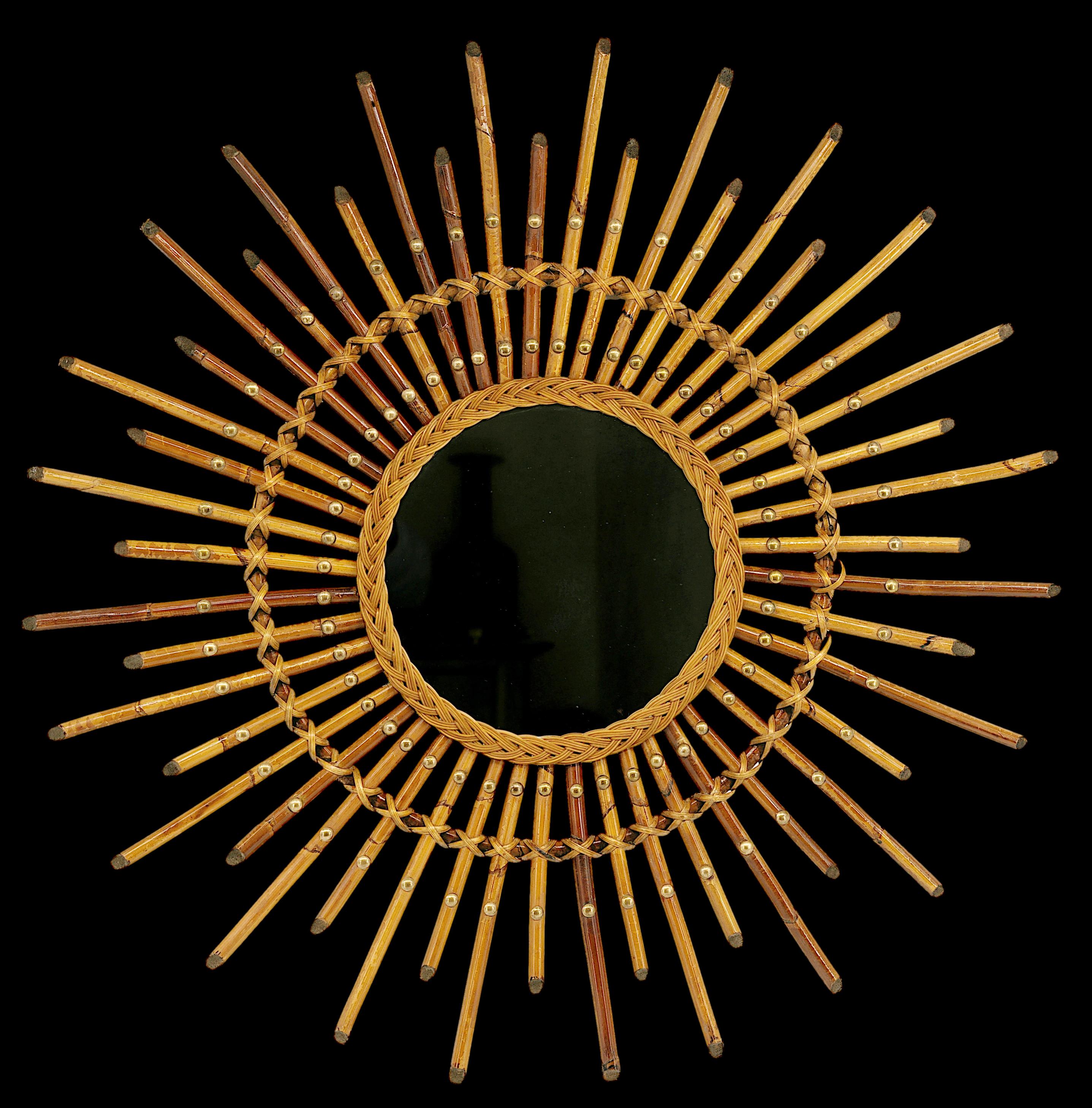 Bamboo Wall Mirror by Louis Sognot, France, 1950s. This stunning bamboo wall mirror, designed by Louis Sognot in the 1950s, combines bamboo, wicker, rattan, and brass to create a striking and unique piece. The mirror's frame is adorned with original