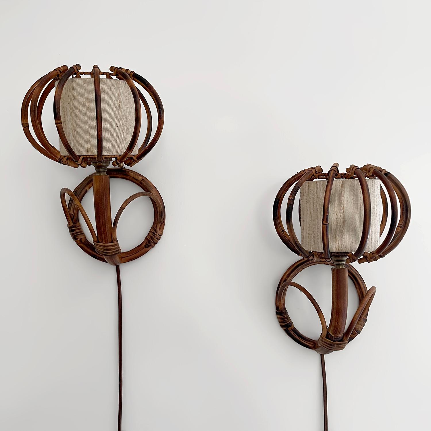 Apliques franceses de bambú y ratán Louis Sognot
Francia, hacia 1960 
Piezas artesanales hechas a mano
El bambú bellamente esculpido crea un brazo de luz ascendente y está unido a una pantalla orbital cilíndrica de ratán calado
Forro interior