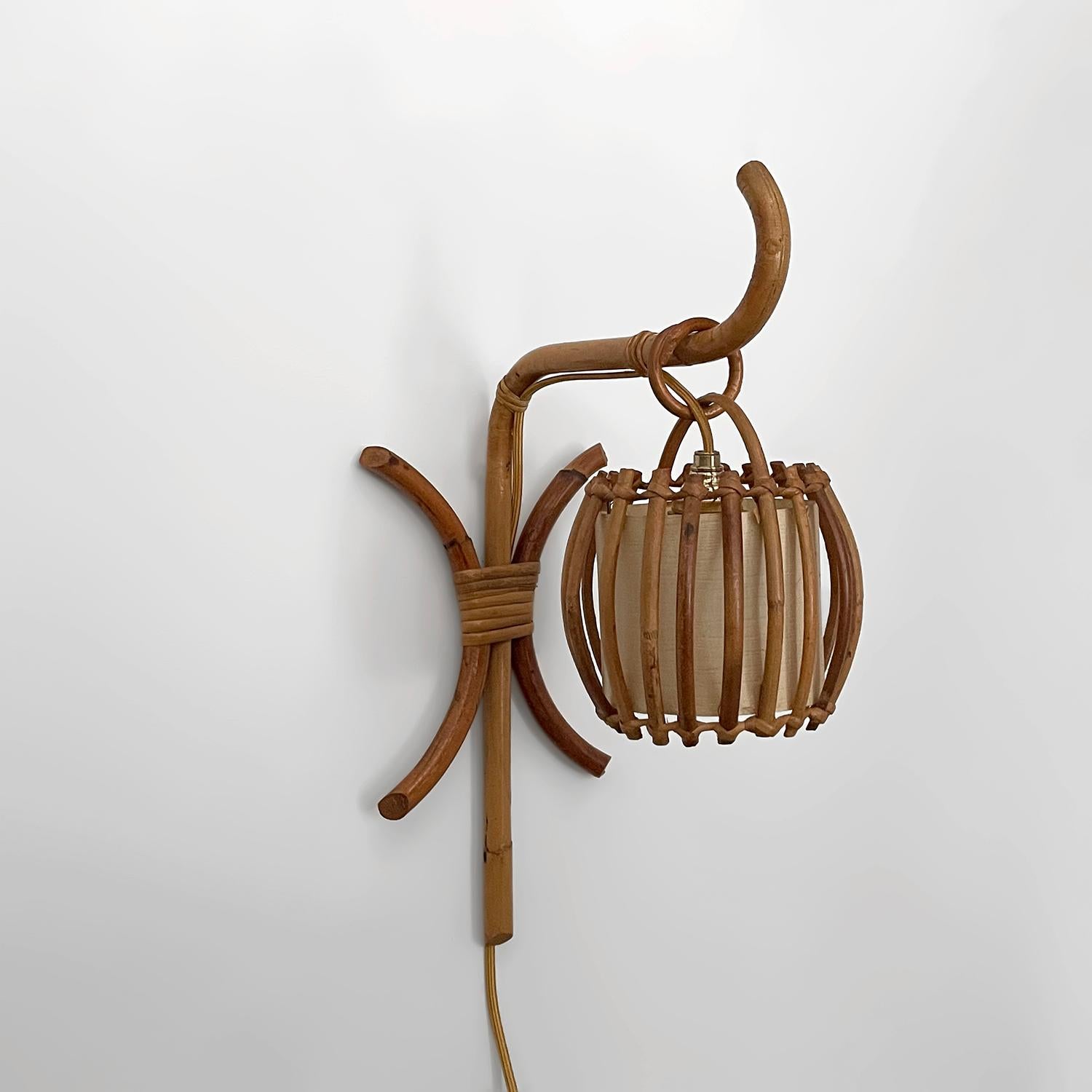 Louis Sognot French rattan single lantern sconce
France, circa 1960s
Handcrafted artisanal piece
Sculptural rattan ascending arm holds a delicate rattan lantern shade
Original interior shade lining
Composed of natural materials
Natural color