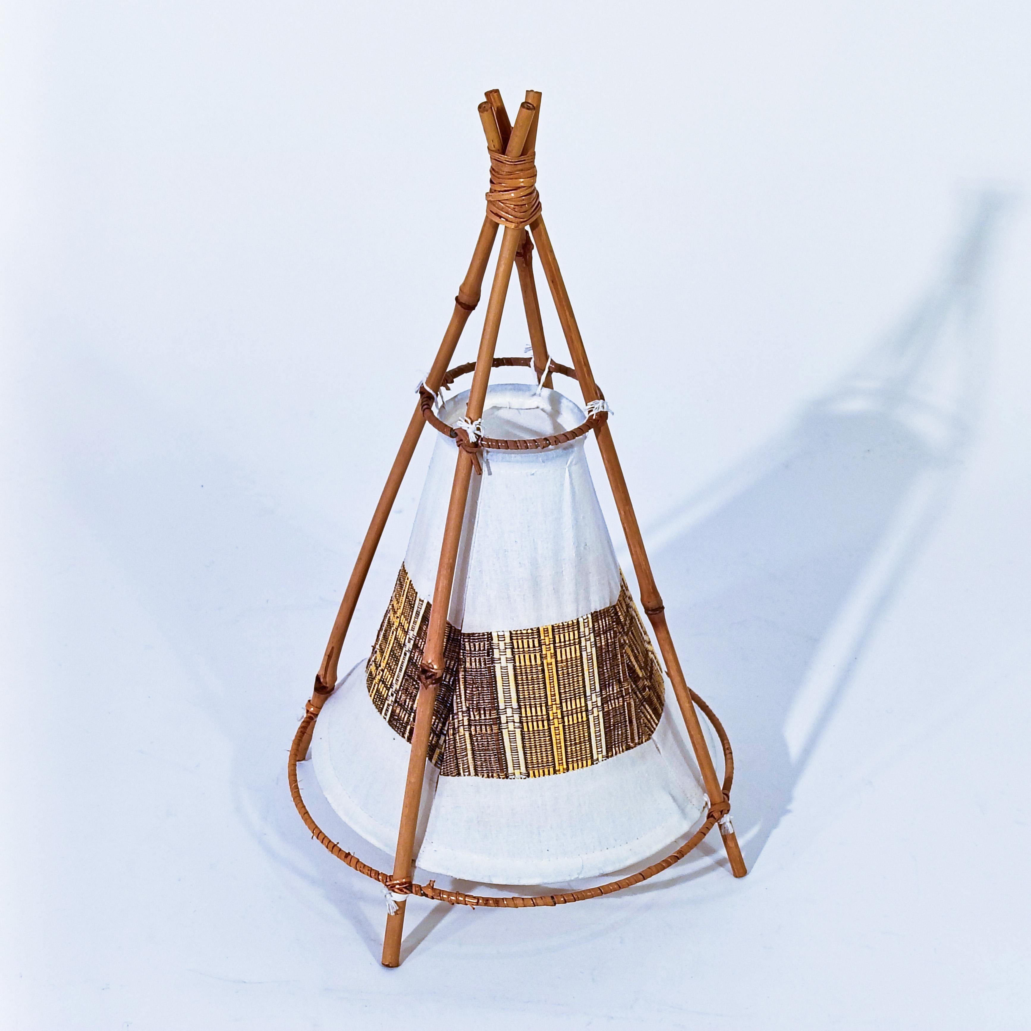 Lámpara de sobremesa estilo Riviera Francesa, Italia, años 60. Diseñada por el arquitecto francés Louis Sognot, esta lámpara tiene una estructura en forma de tienda o tipi y está hecha de caña curada al fuego y ratán, con un difusor de algodón