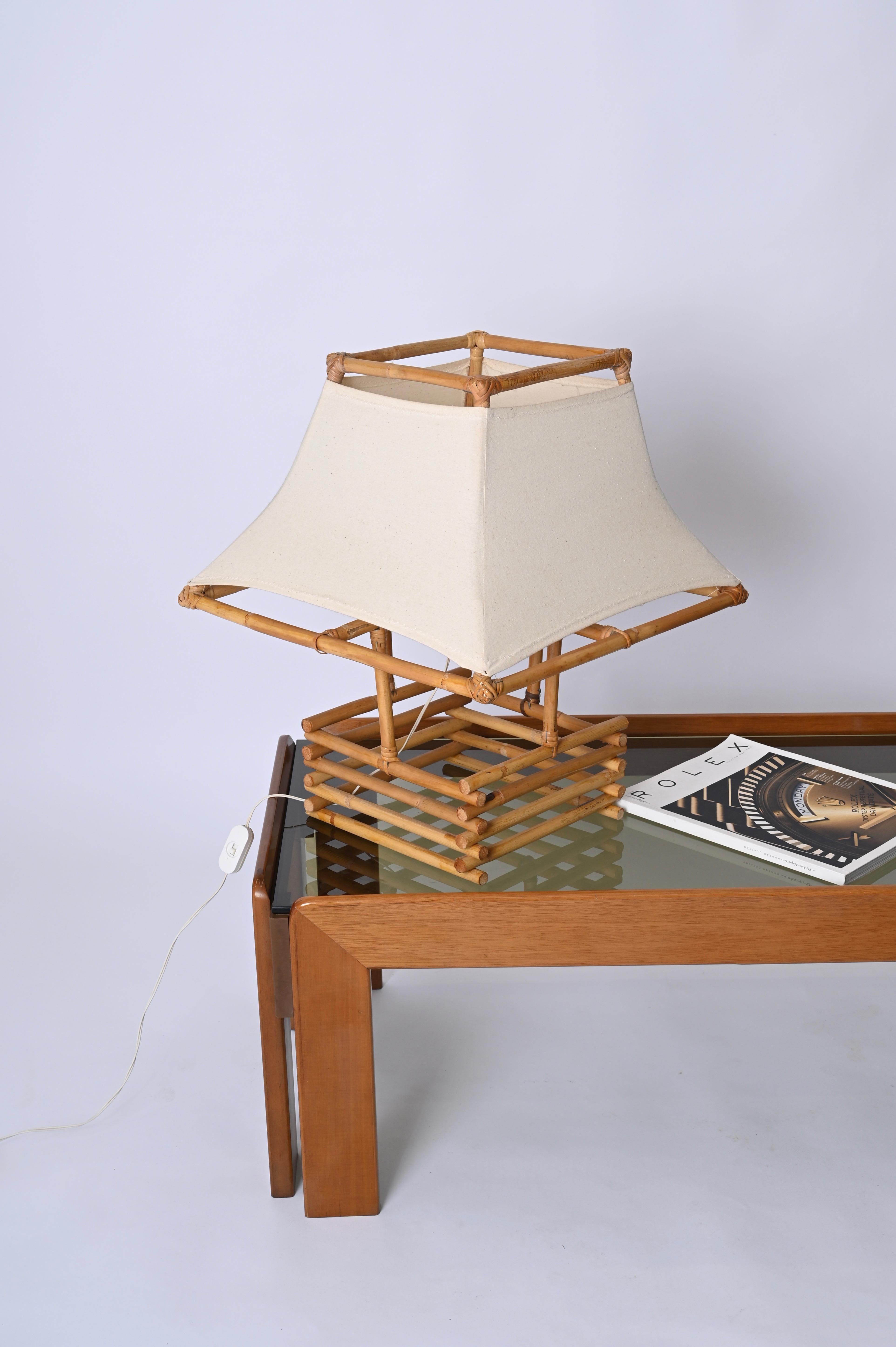 Fantastic large midcentury table lamp in rattan, bamboo and fabric. This lovely piece was made in France in the 1960s and is attributed to Louis Sognot.

The lamp is striking because of its dimensions and design.  It features a clear example of '60s