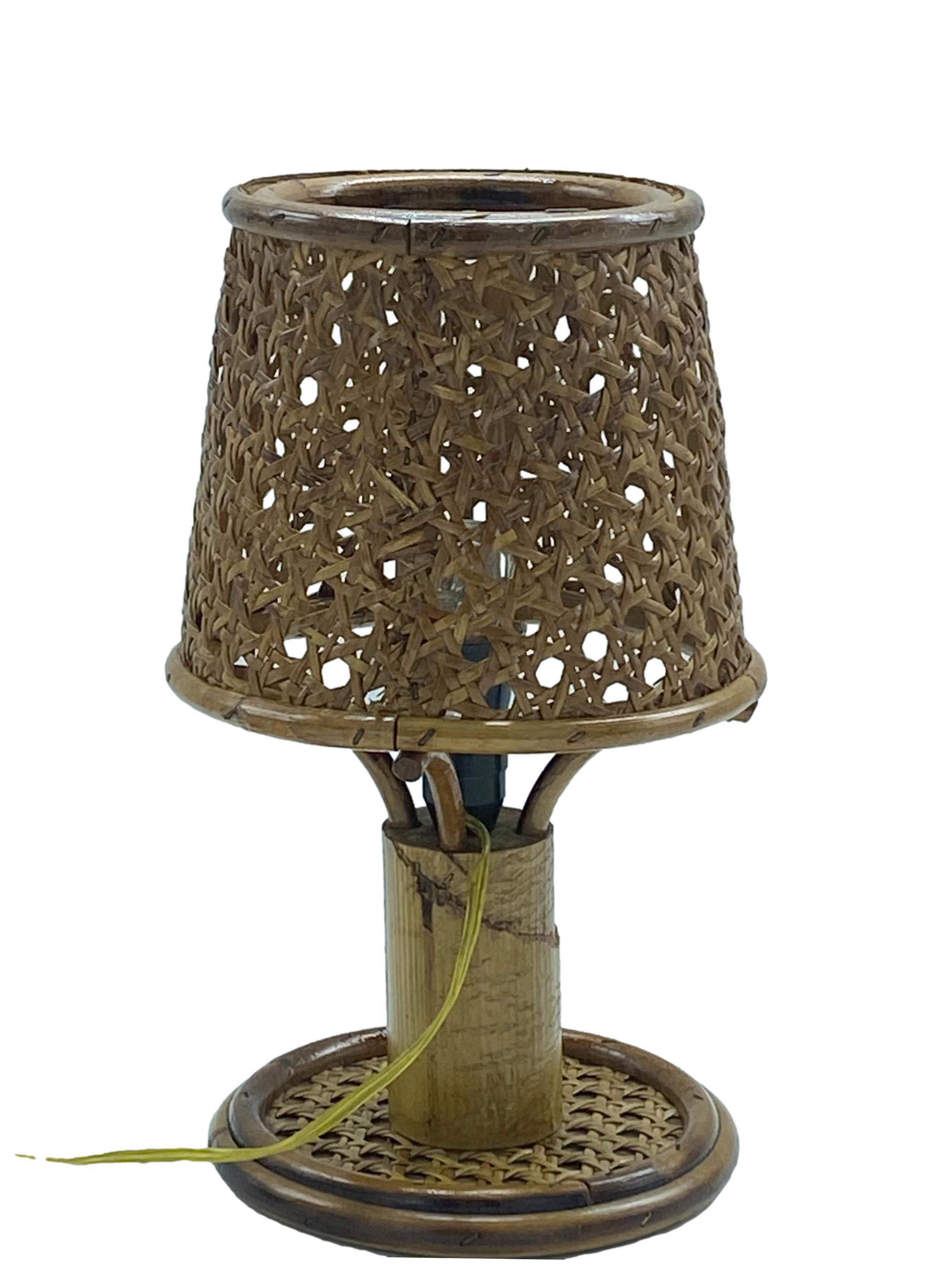 Delightful little table or bedside lamp made from bamboo and rattan. The shade is made of Viennese mesh, while the base shows a rattan and bamboo construction. 
 