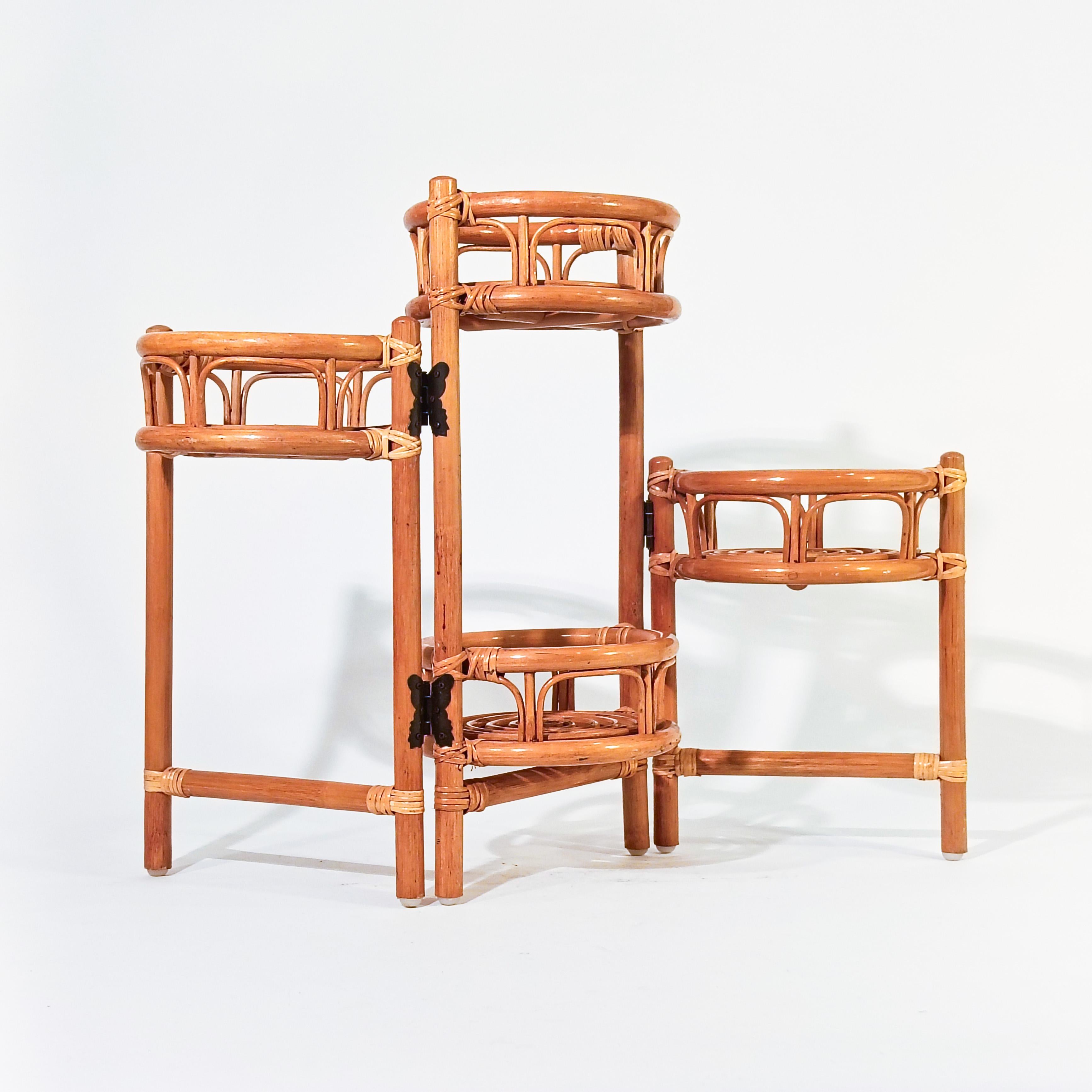 Jardinière pliante de style Foldes, Italie, années 1970. Structure en bois et rotin avec 3 parties pliables, créant 4 espaces pour les pots et les plantes. Le diamètre des espaces réservés aux plantes est de 20,5 cm. Tout à fait dans le style des