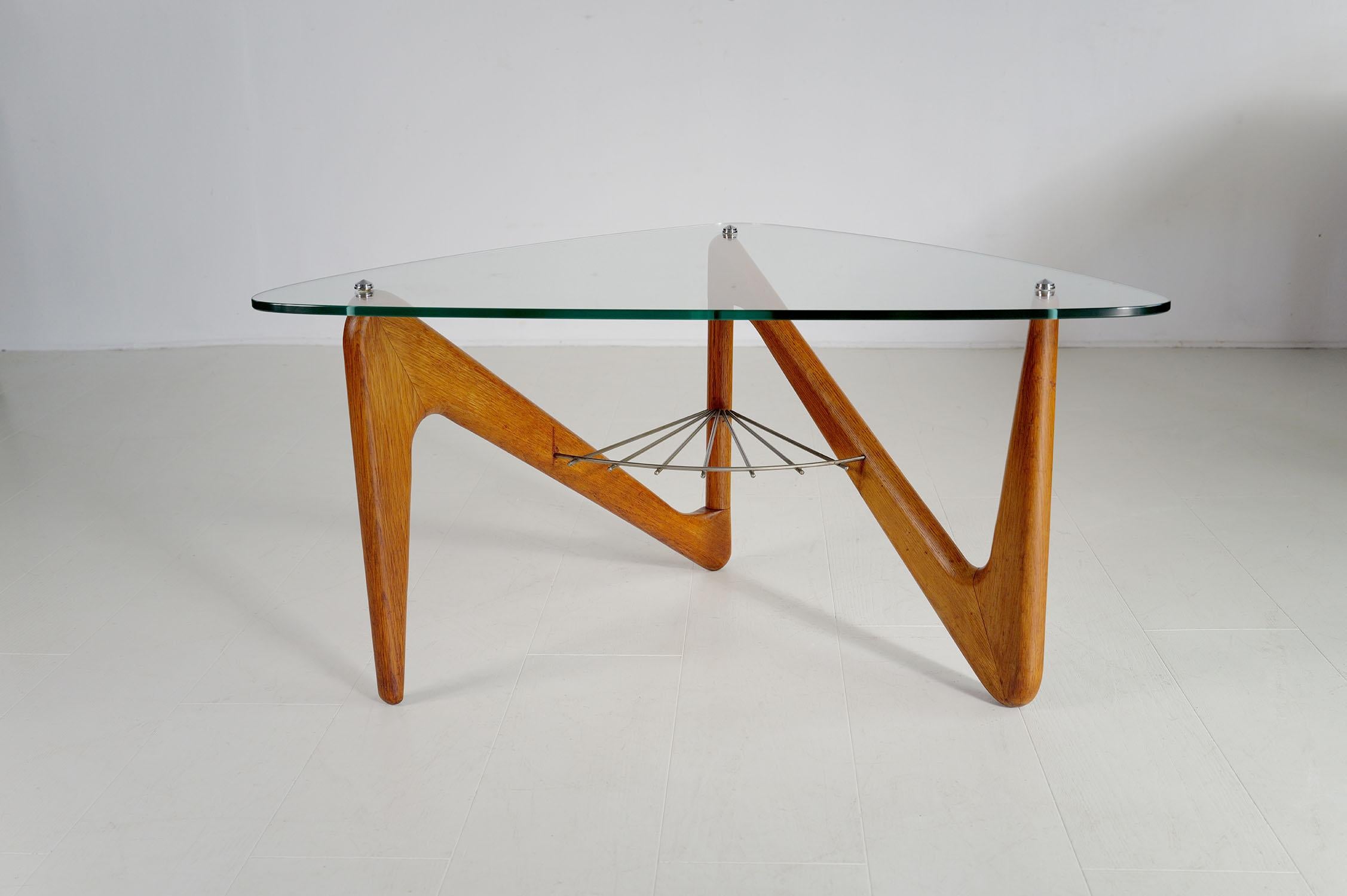 Table basse en chêne de Louis Sognot, France 1950. Le plateau de forme libre repose sur une base en forme de boomerang, reliée par une étagère en rondins d'acier laqué gris d'origine. Très bon état, plateau en verre refait à l'origine.